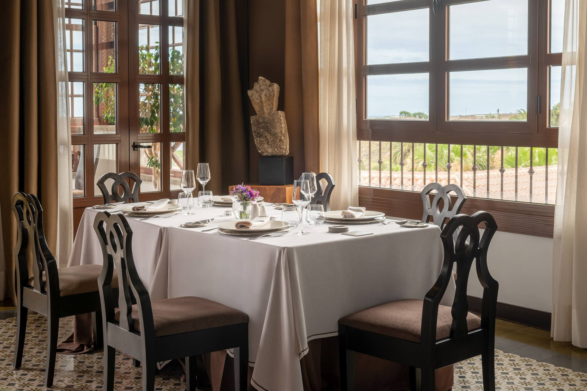 Restaurant dining room with elegant table setting and scenic window view.