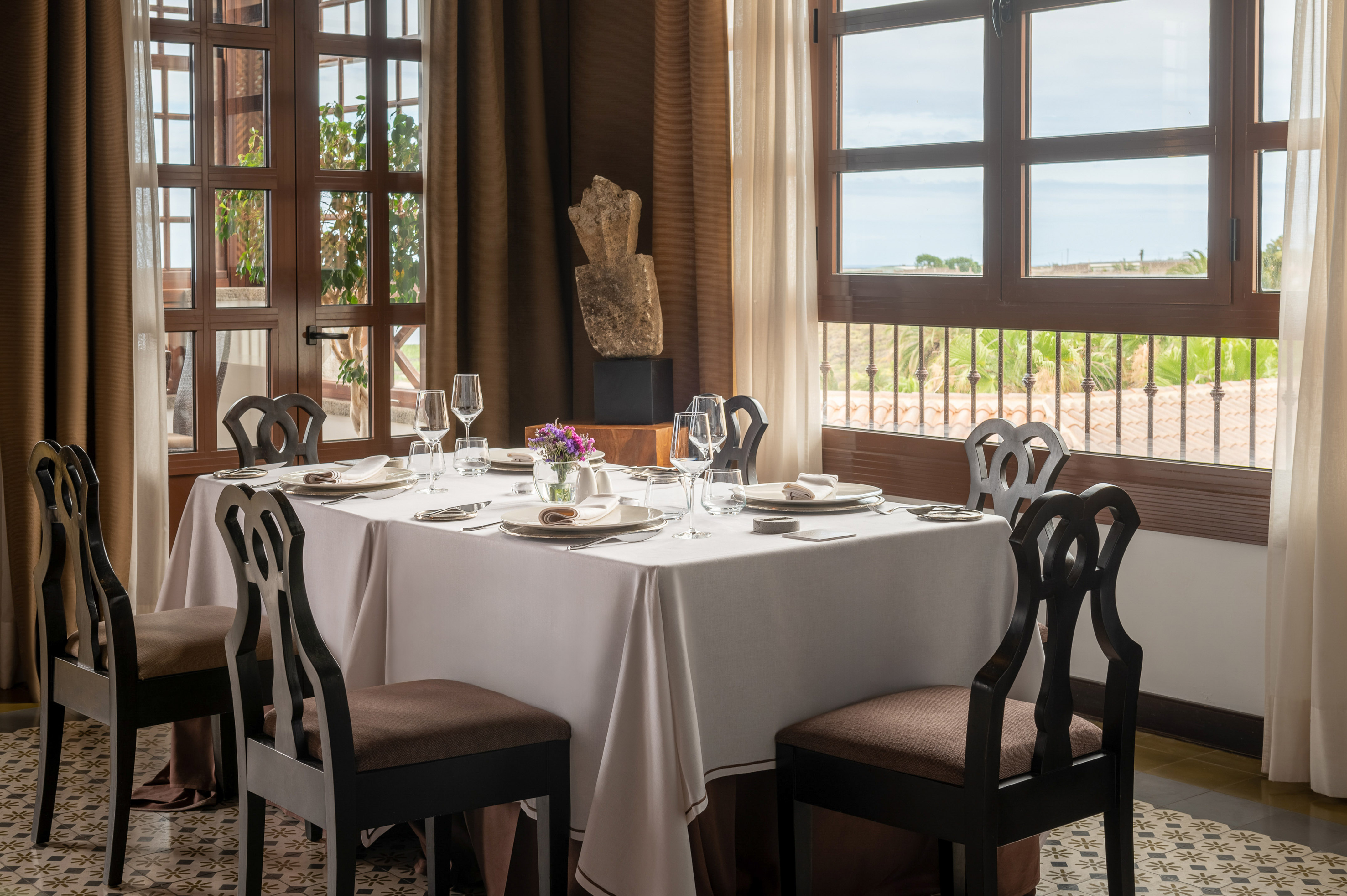 Restaurant dining room with elegant table setting and scenic window view.