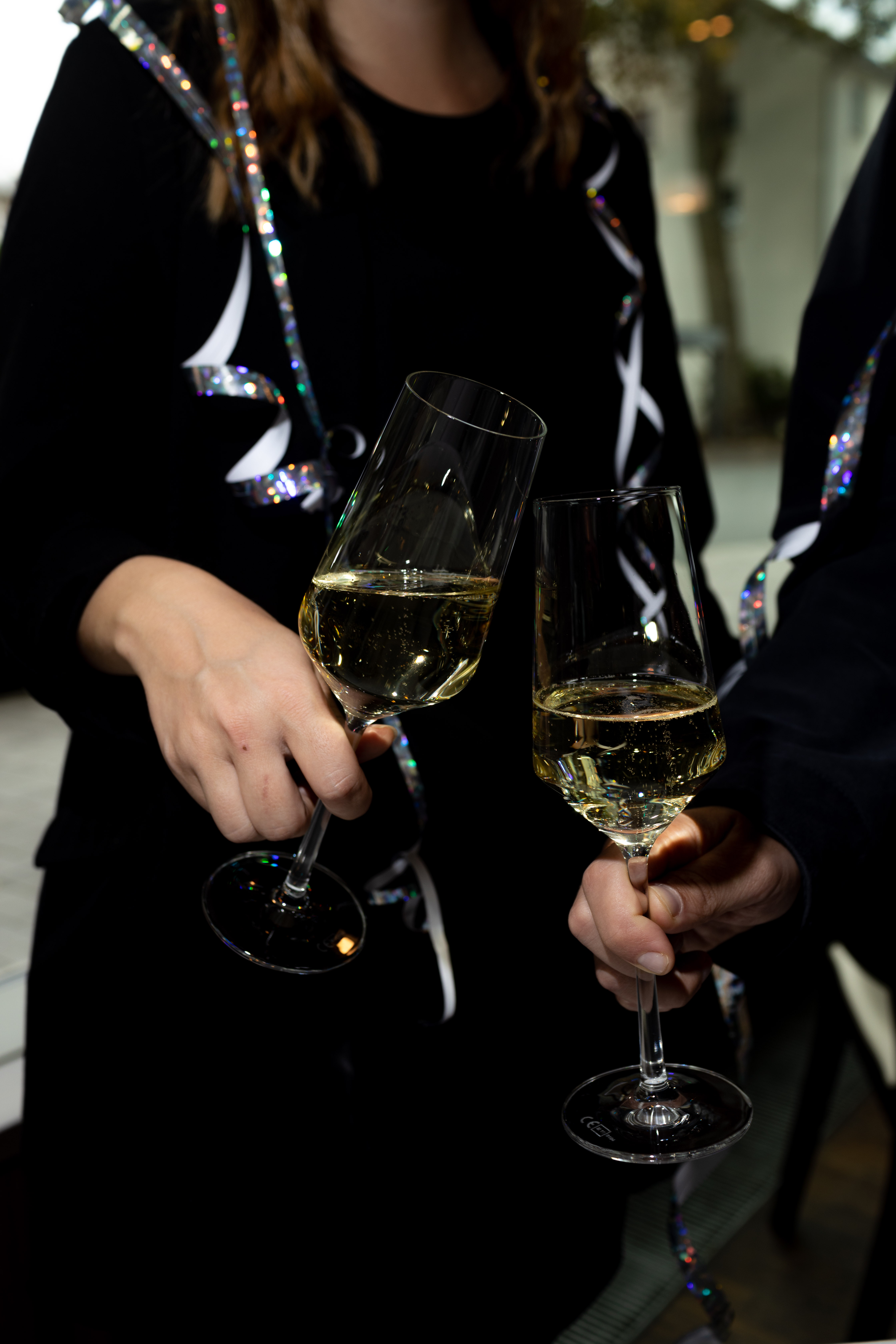 a pair of hands holding wine glasses