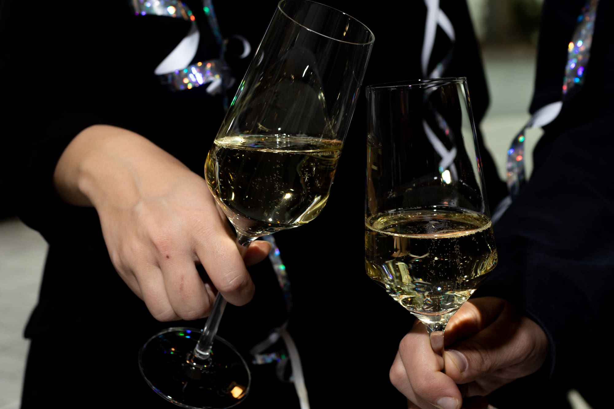 a pair of hands holding wine glasses