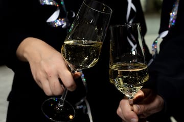 a pair of hands holding wine glasses