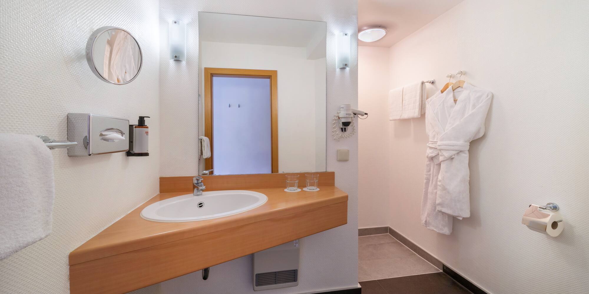a bathroom with a white robe and a sink