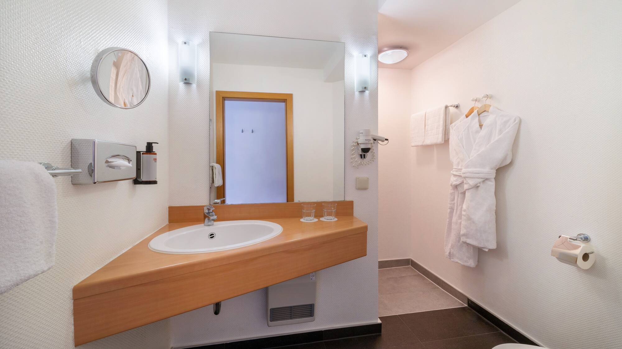 a bathroom with a white robe and a sink
