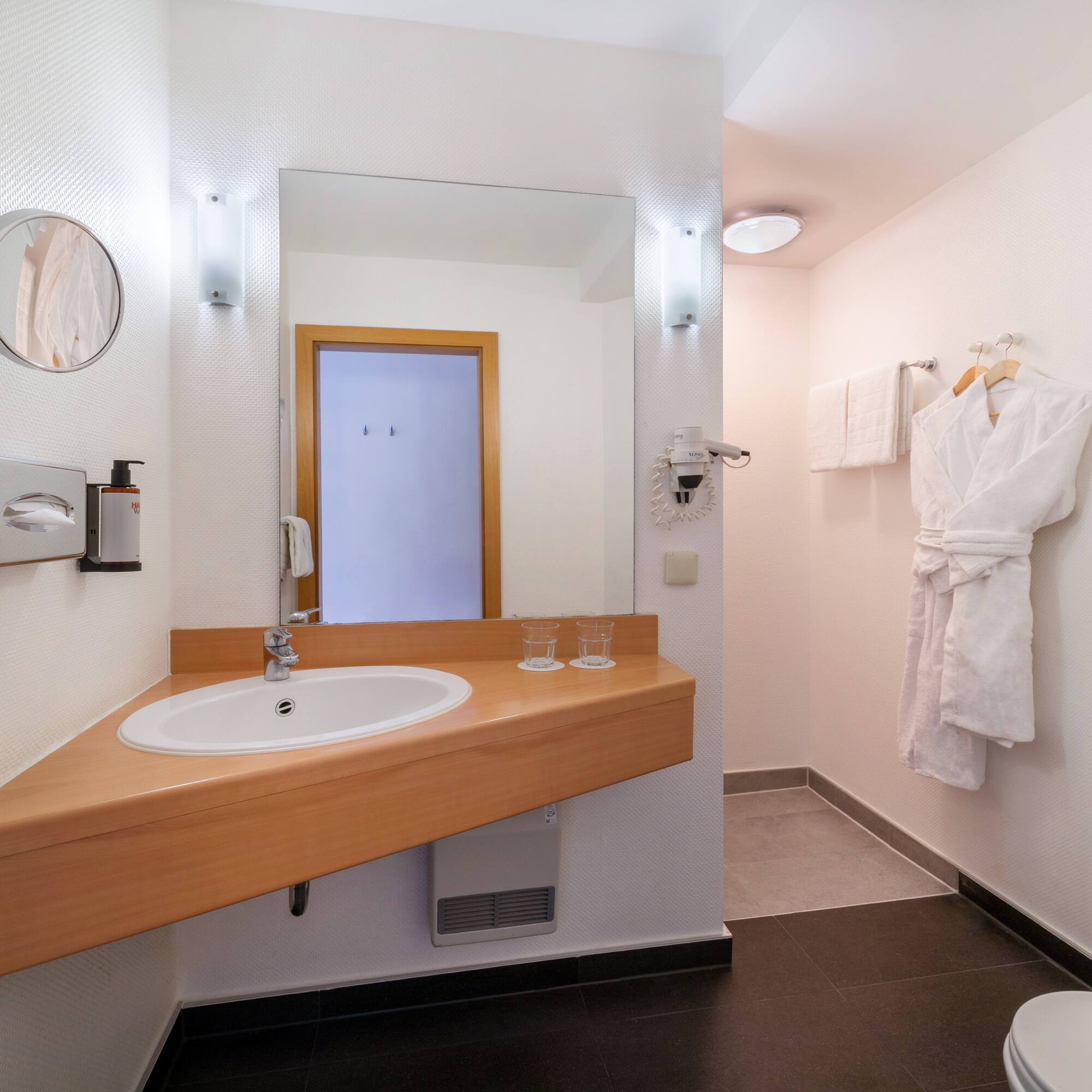 a bathroom with a white robe and a sink
