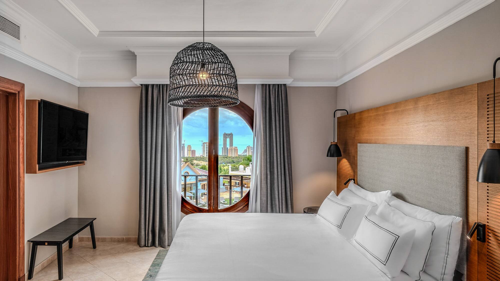 a bedroom with a large bed and a round window