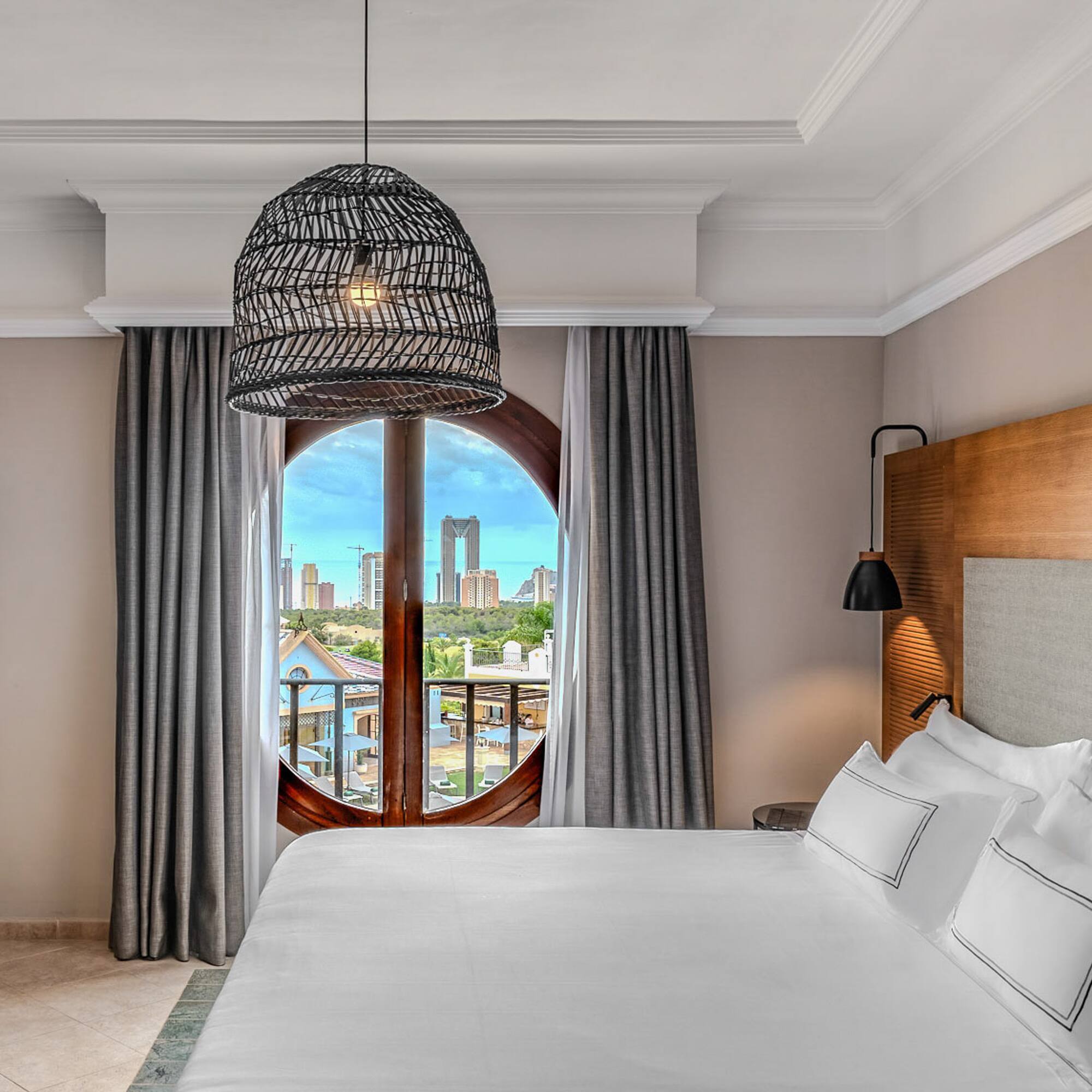 a bedroom with a large bed and a round window