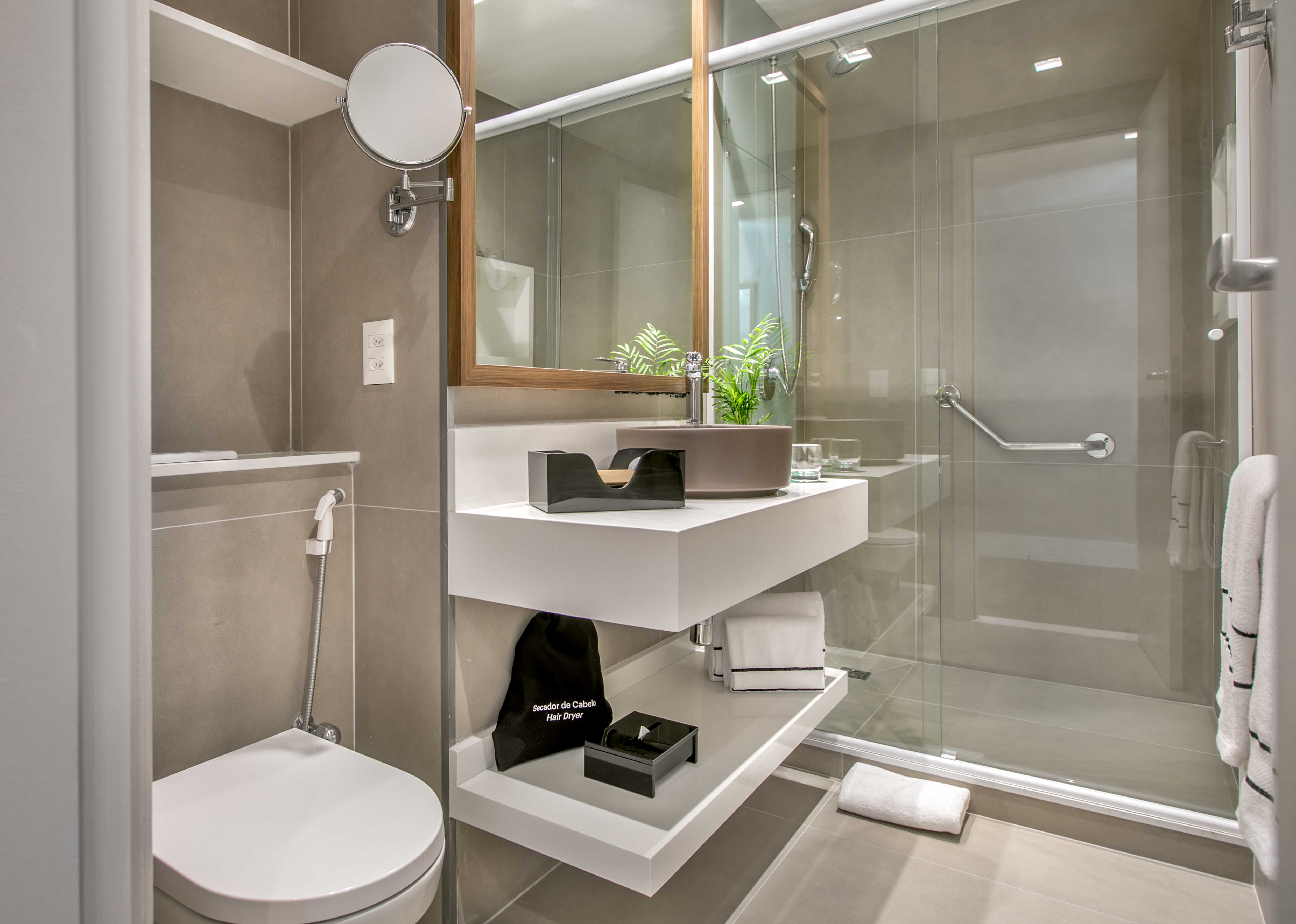 Contemporary bathroom with floating vanity, toilet, and glass enclosed shower.
