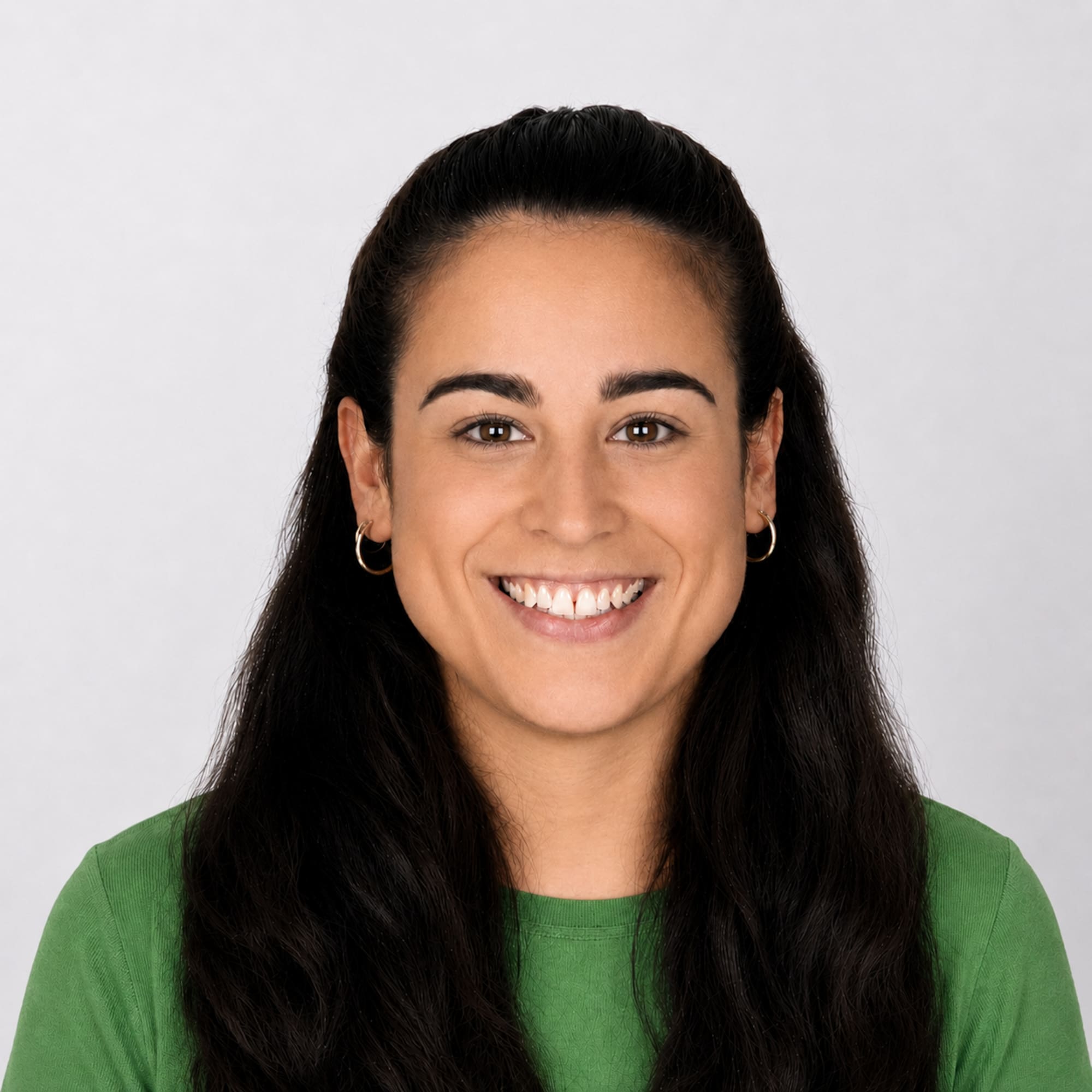 Professional headshot of a smiling woman with dark hair and green shirt.