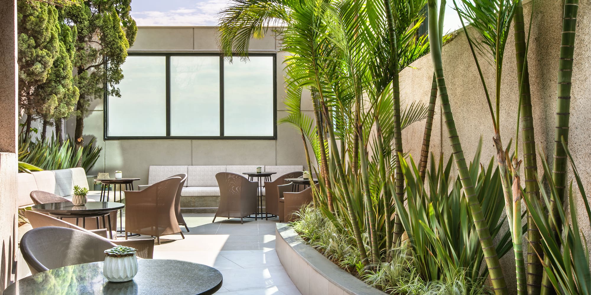 a patio with tables and chairs and plants