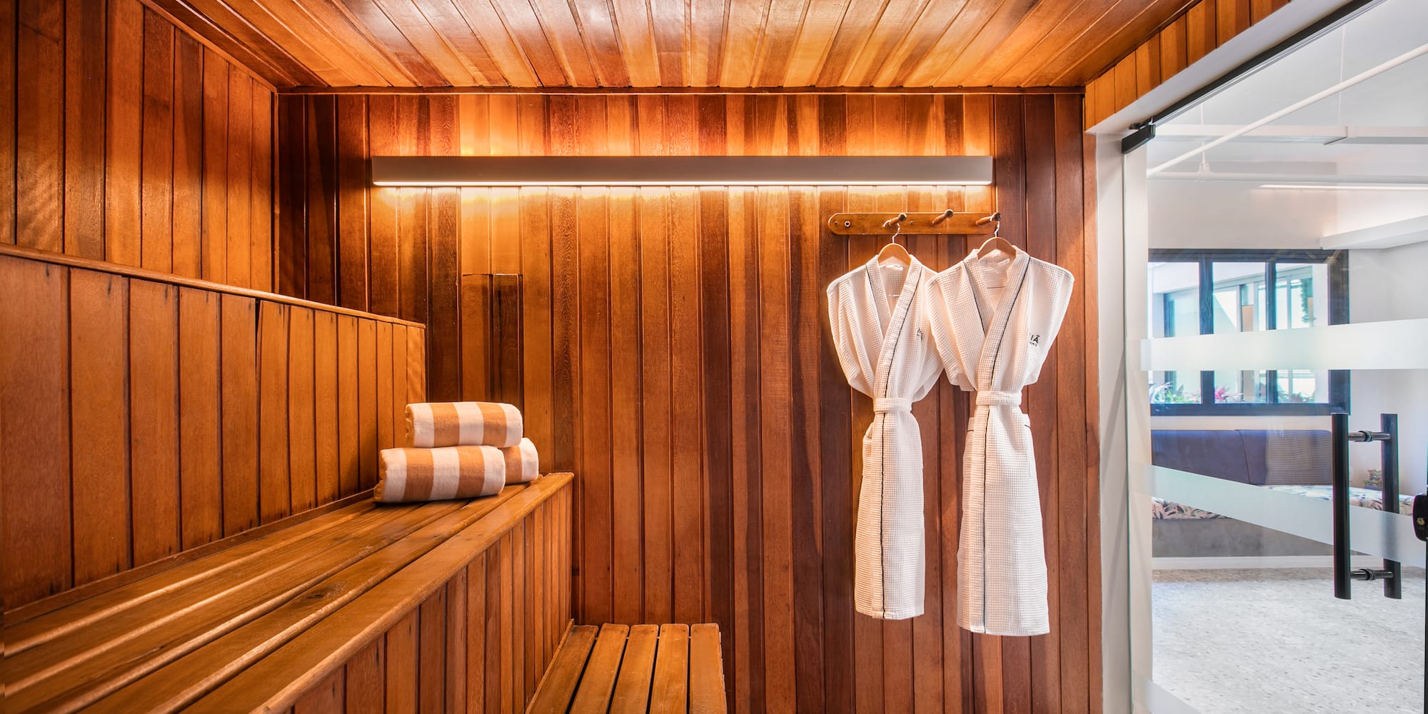 a sauna with towels on a rack