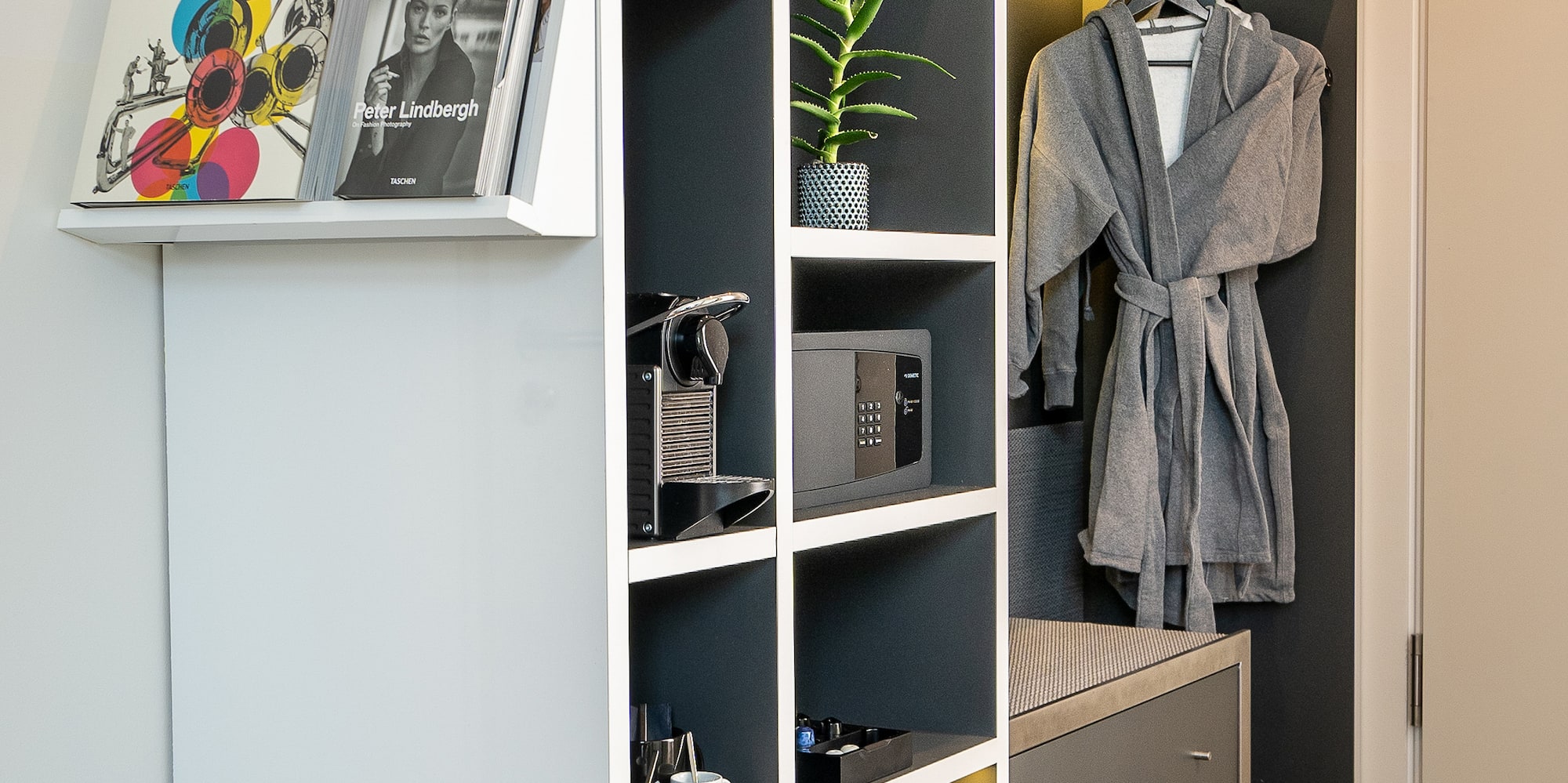 a closet with shelves and a robe