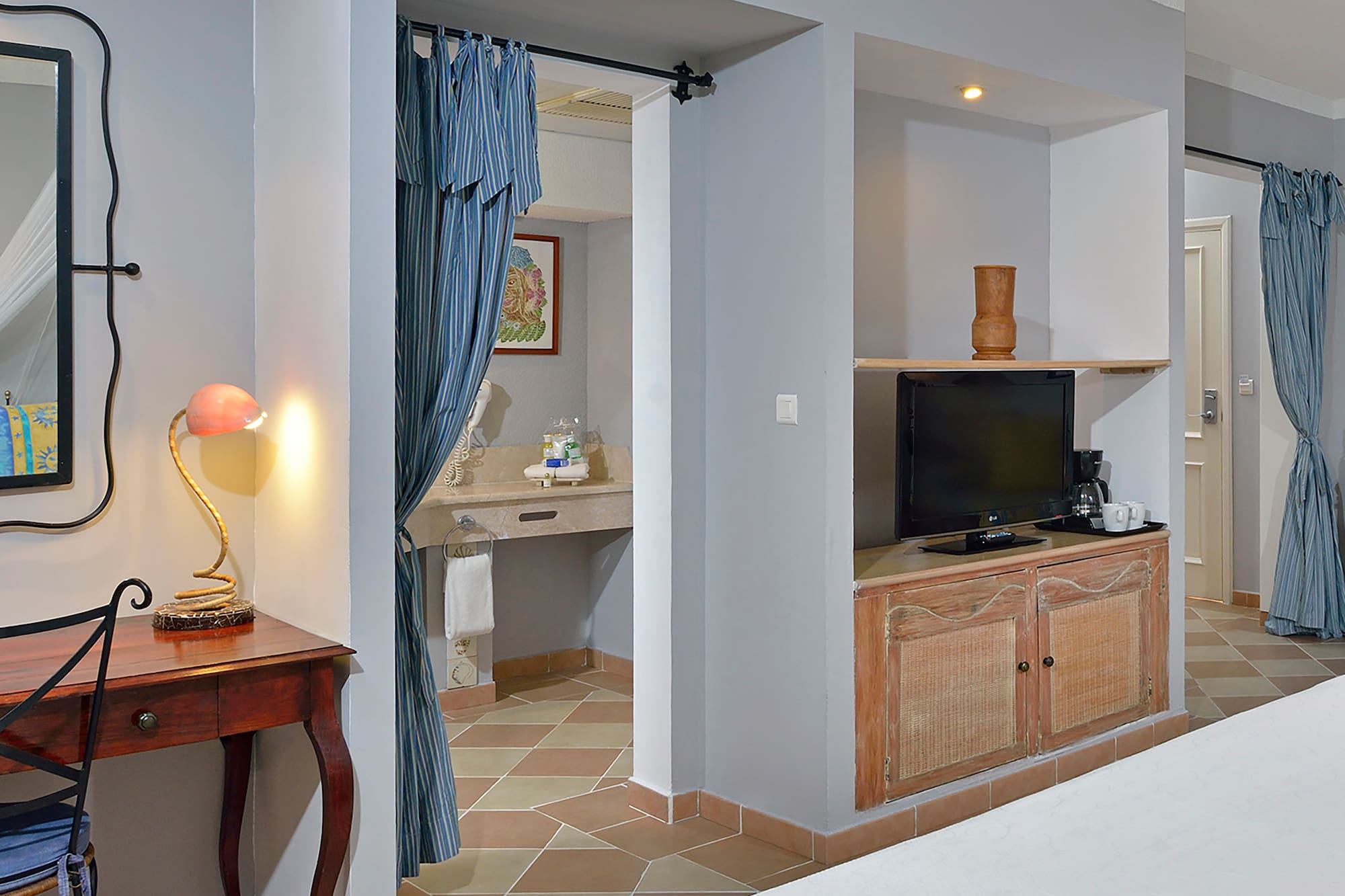 a room with a bed and a desk and a mirror