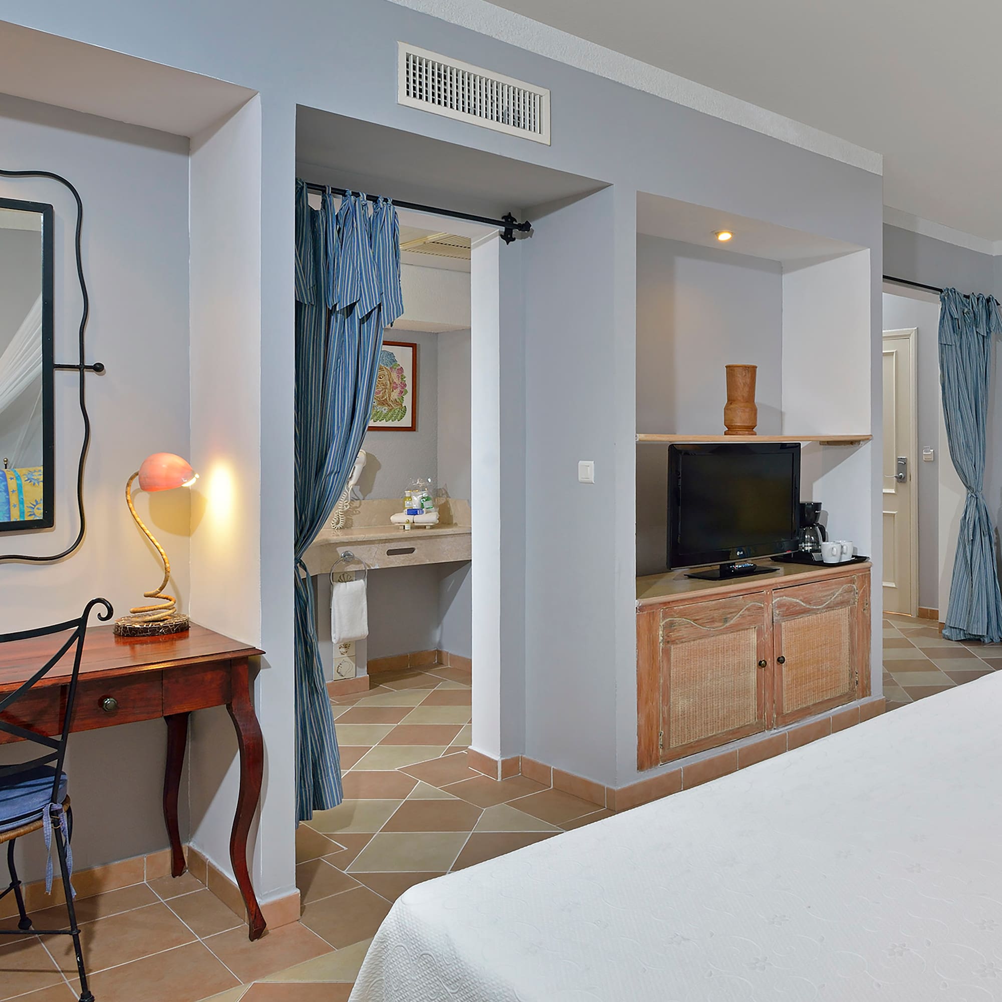 a room with a bed and a desk and a mirror