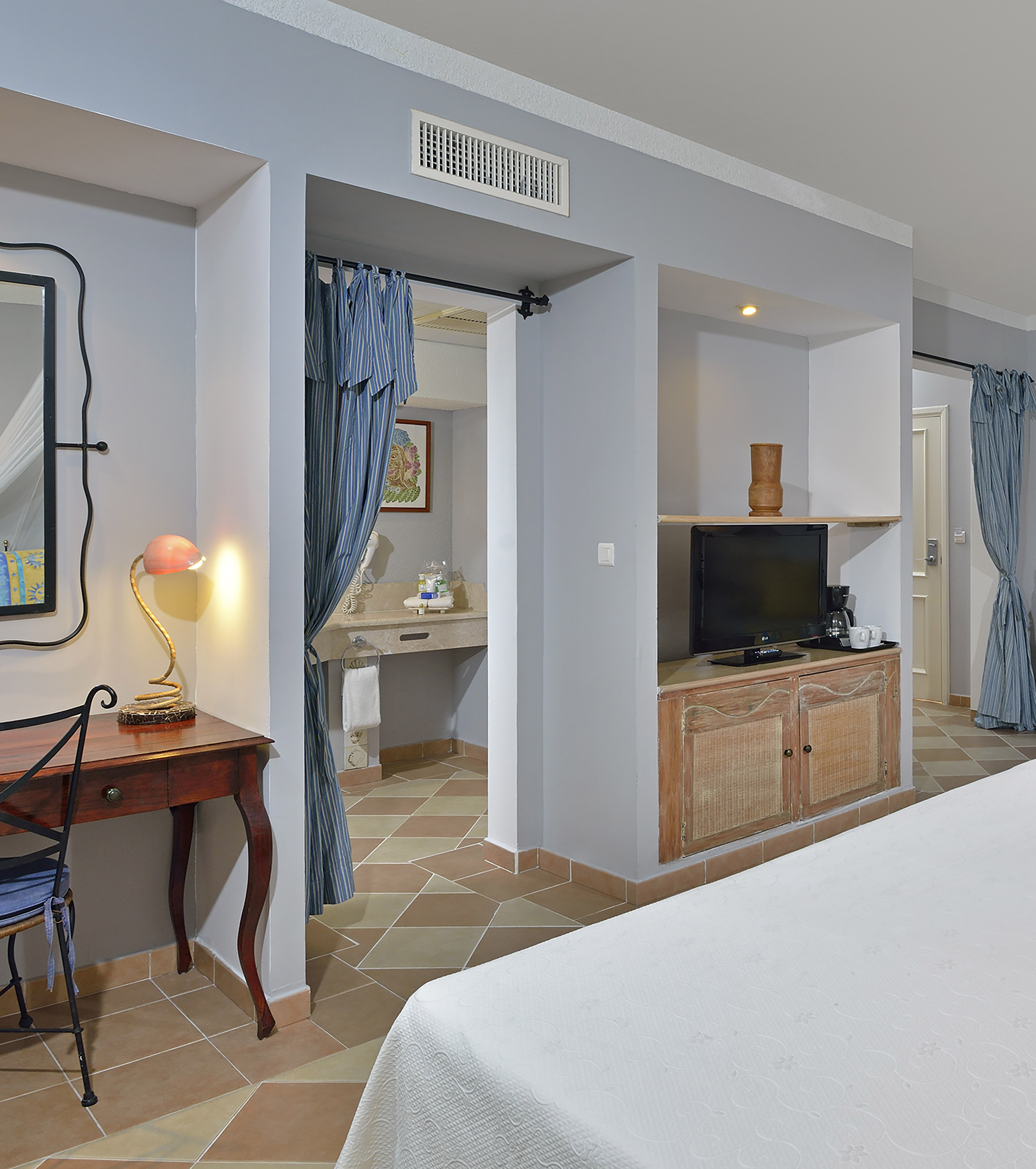 a room with a bed and a desk and a mirror