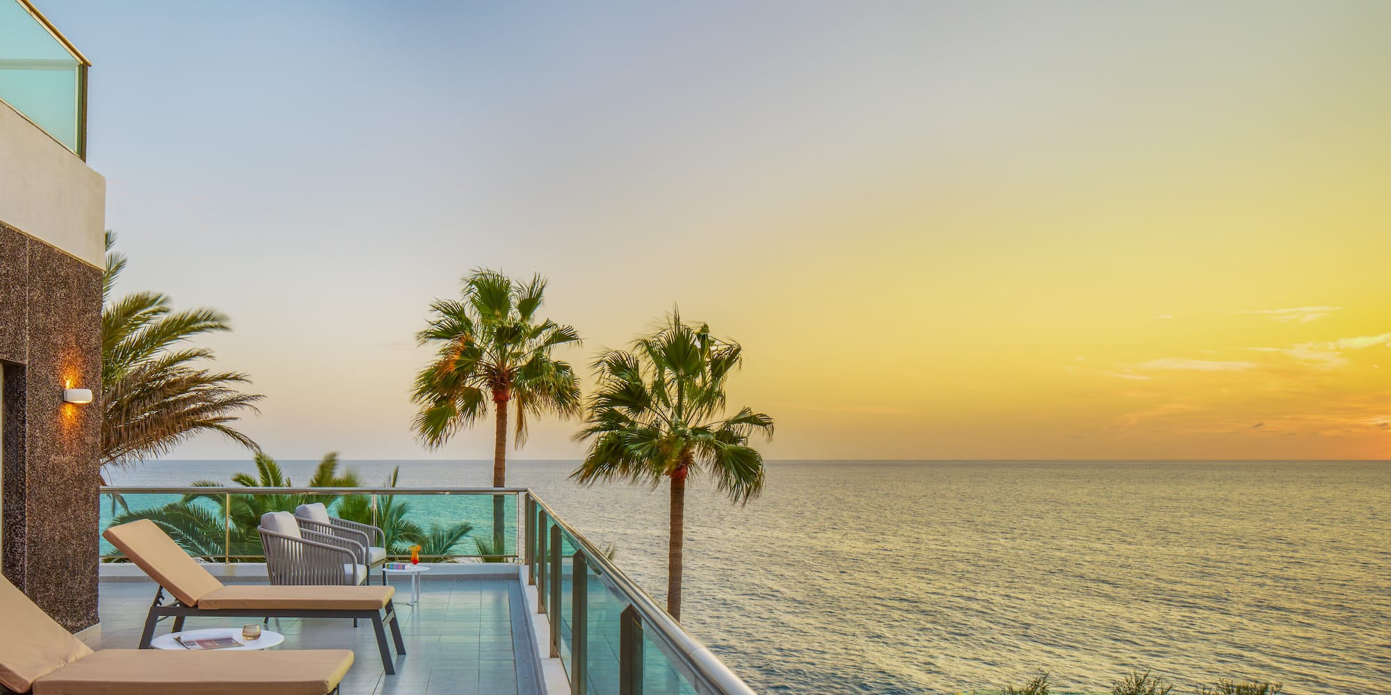 a deck with chairs and a pool overlooking the ocean