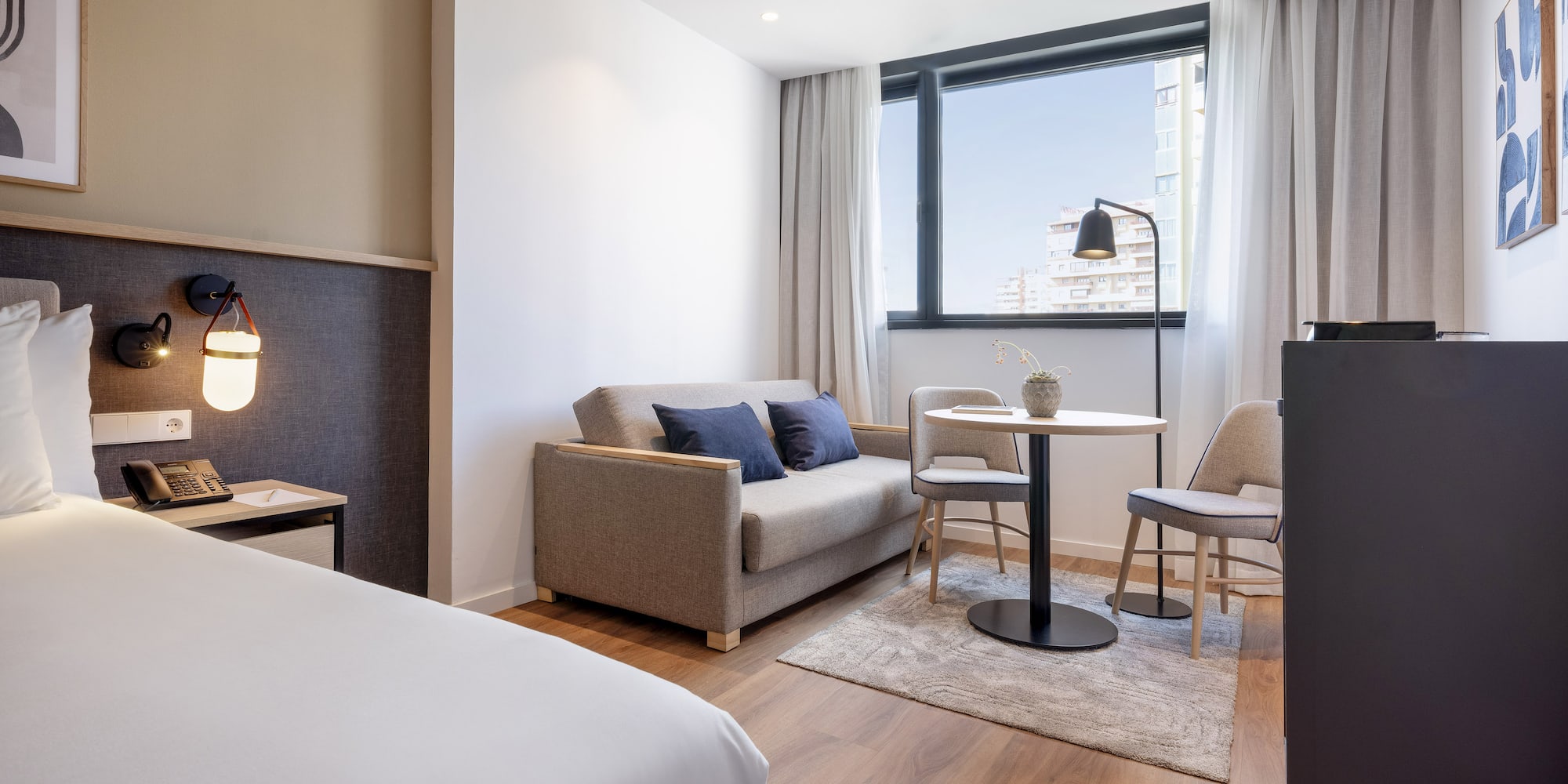 a room with a bed and a table and chairs