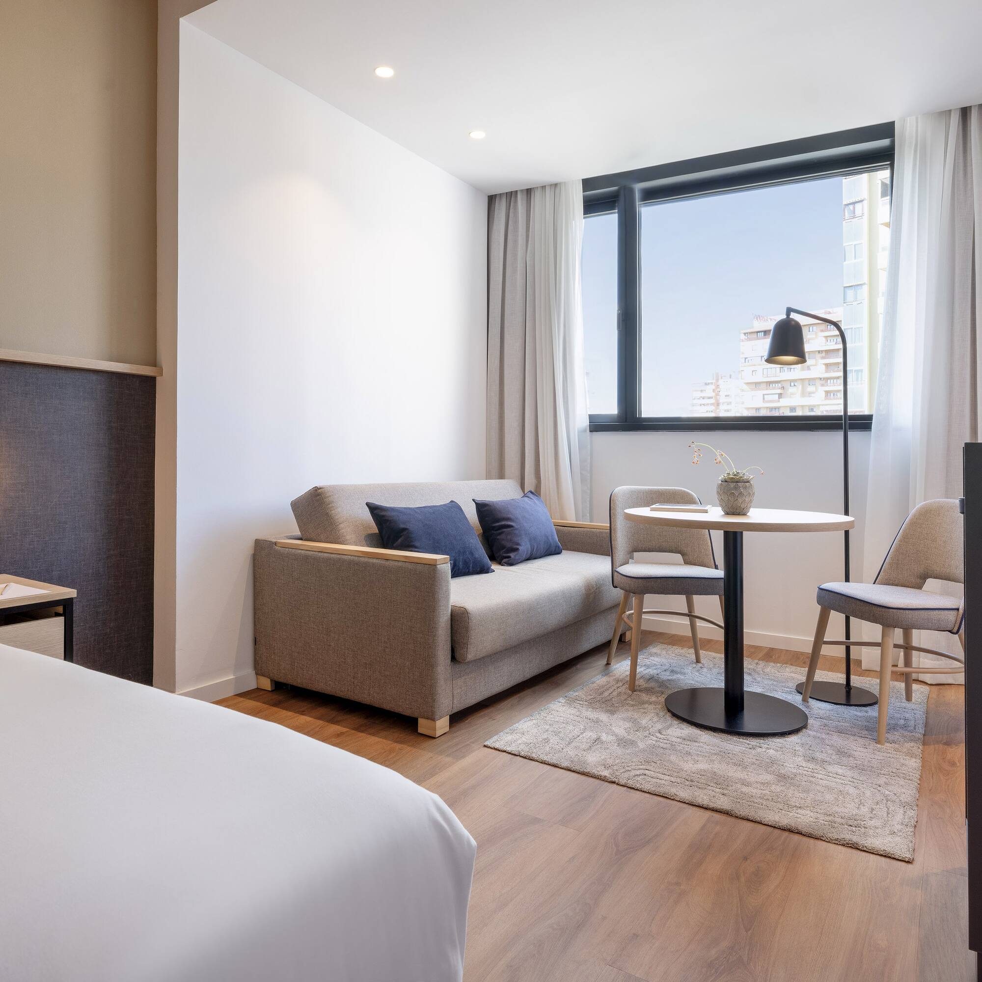 a room with a bed and a table and chairs