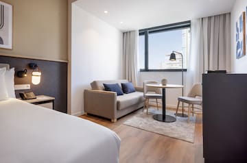 a room with a bed and a table and chairs