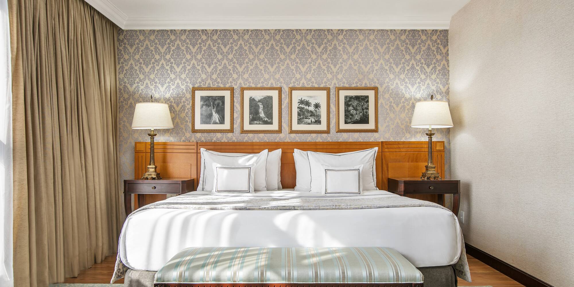 a bed with lamps and a bench in a room