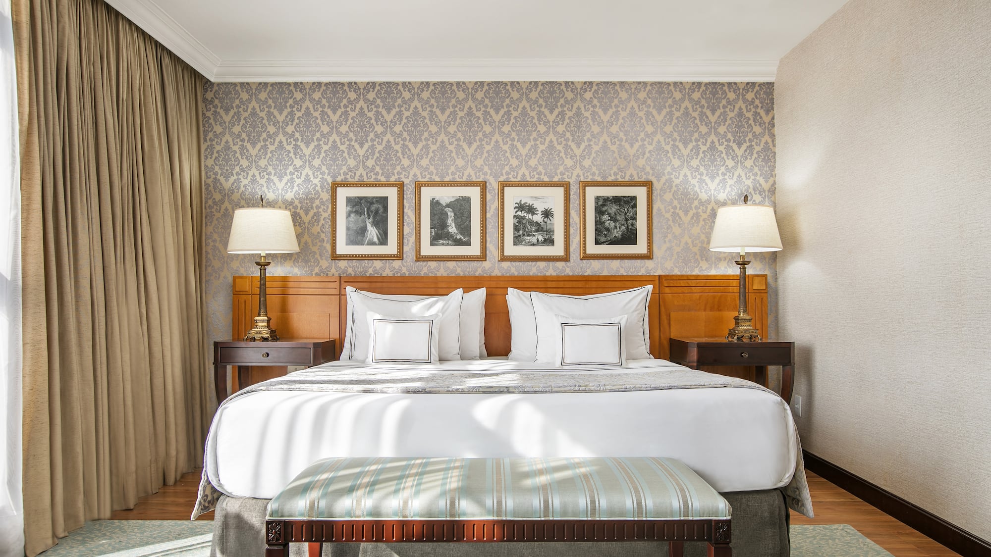 a bed with lamps and a bench in a room