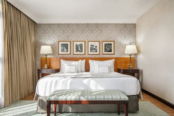 a bed with lamps and a bench in a room