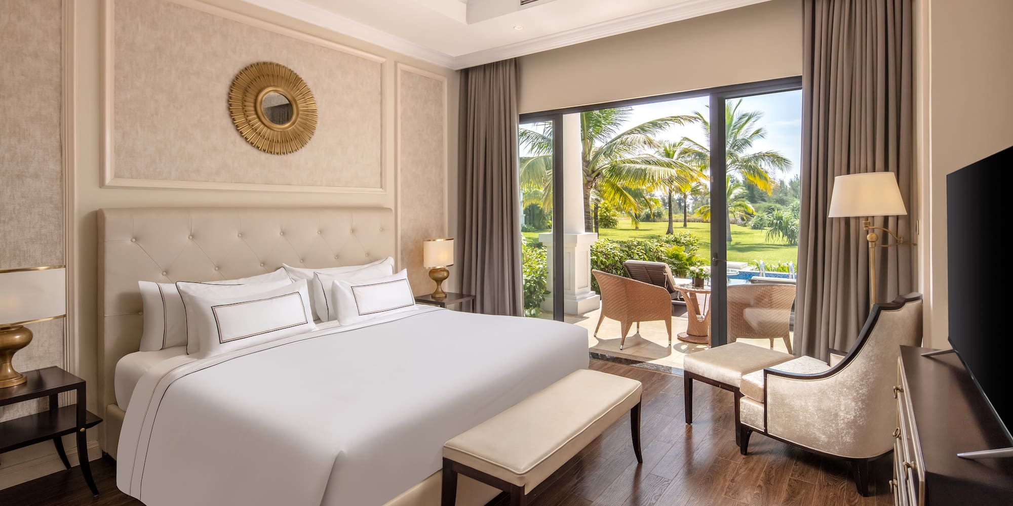 a bedroom with a large bed and chairs