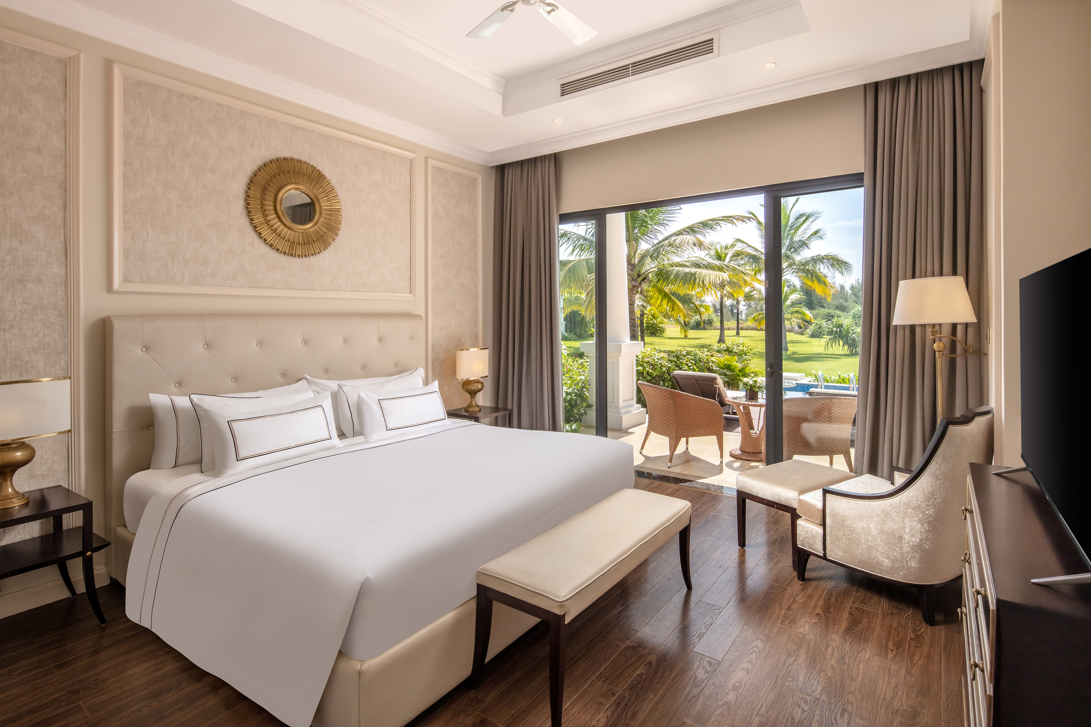 a bedroom with a large bed and chairs