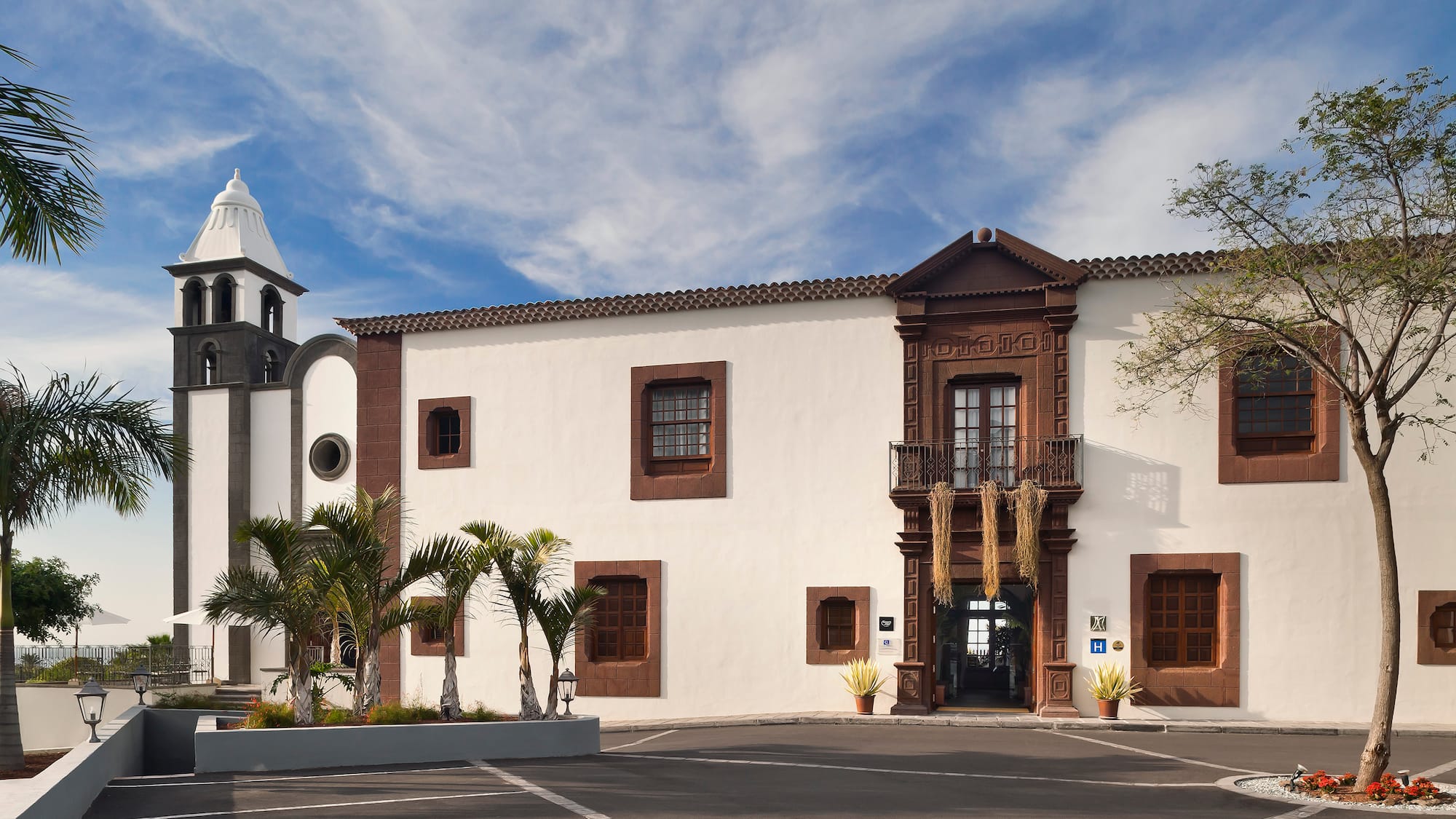 a building with palm trees and a bell tower