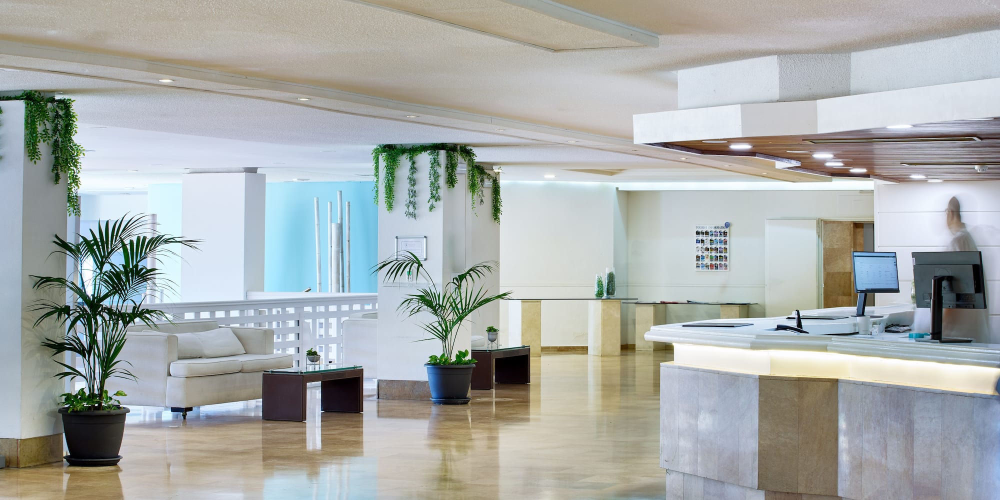 a large room with a reception desk and a white couch