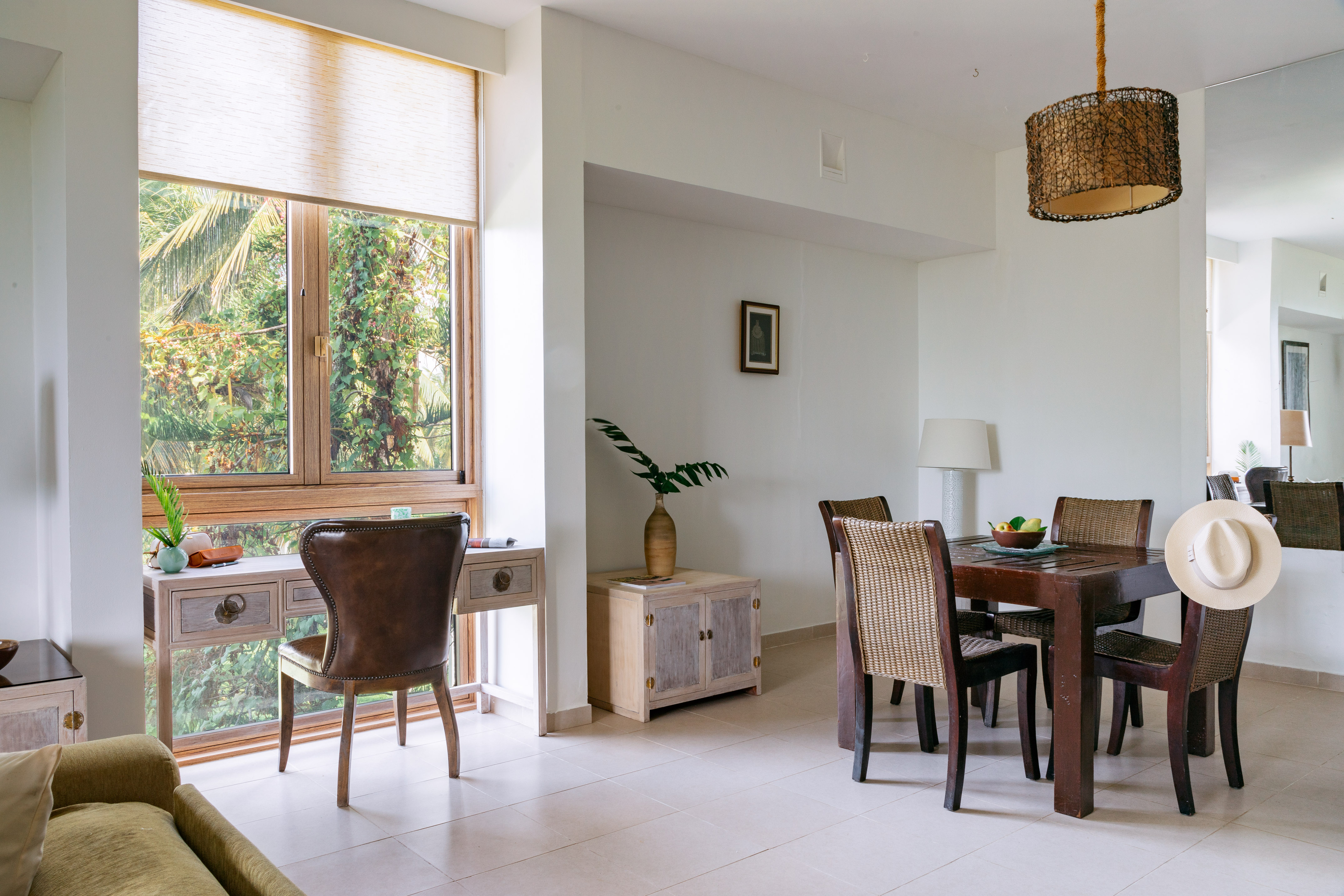 Tropical dining and workspace with window overlooking lush greenery.