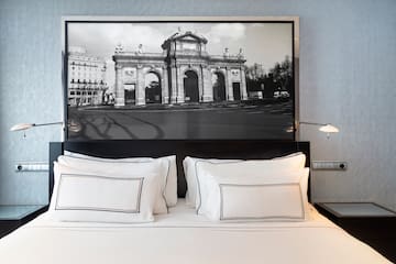 a bed with a picture above it