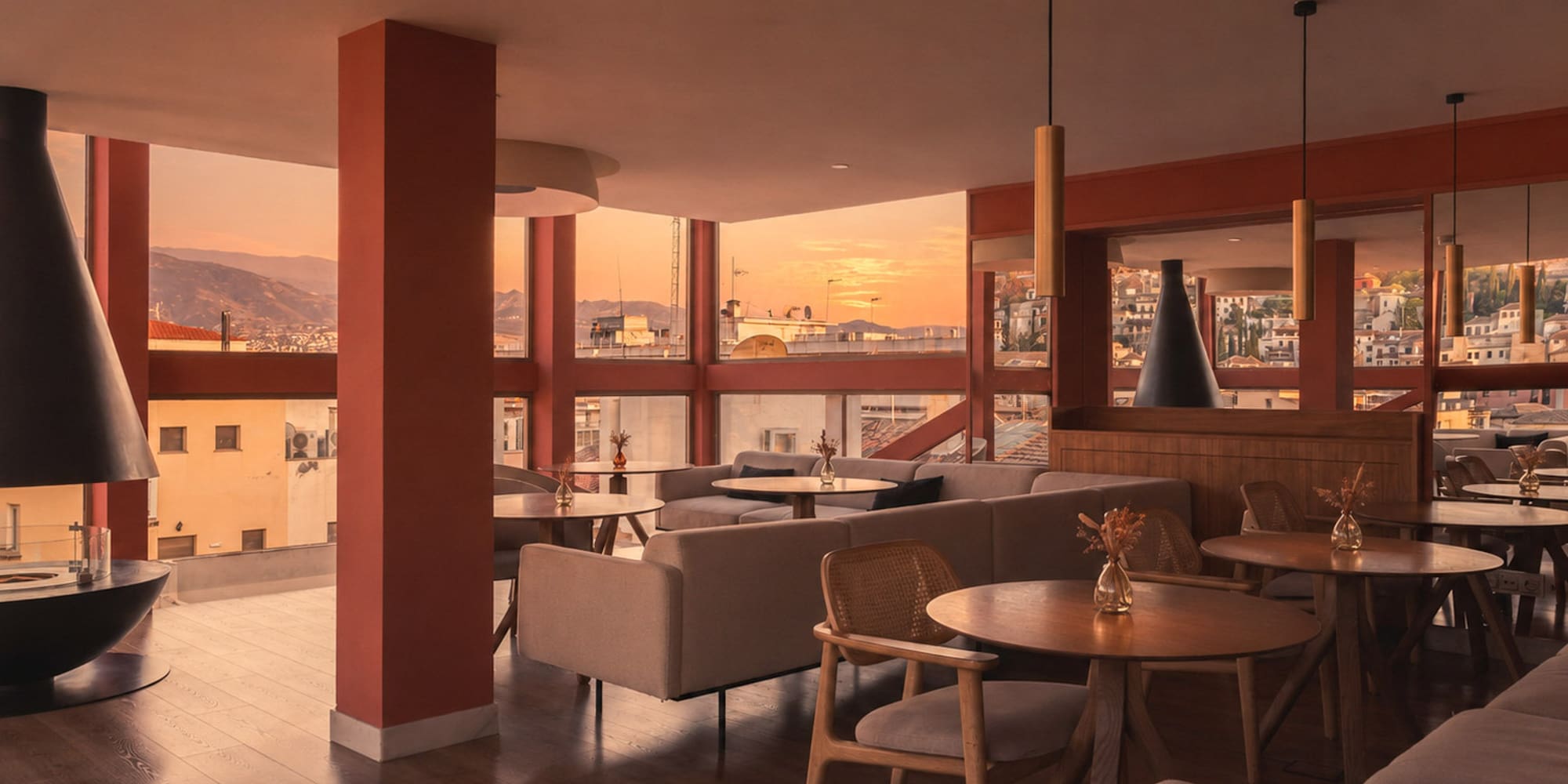 Warm modern lounge with sunset city views, stylish seating, and fireplace.