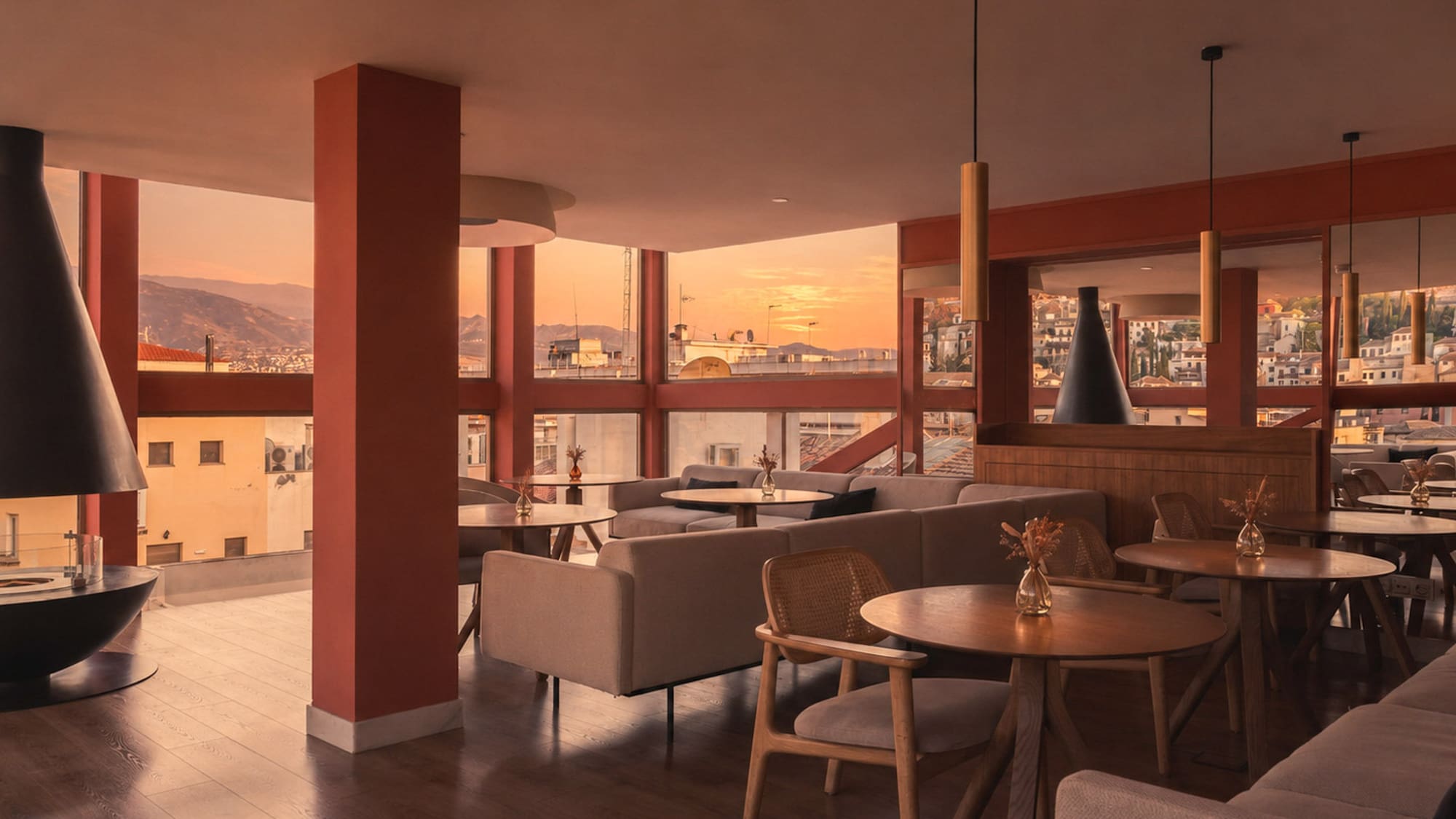 Warm modern lounge with sunset city views, stylish seating, and fireplace.