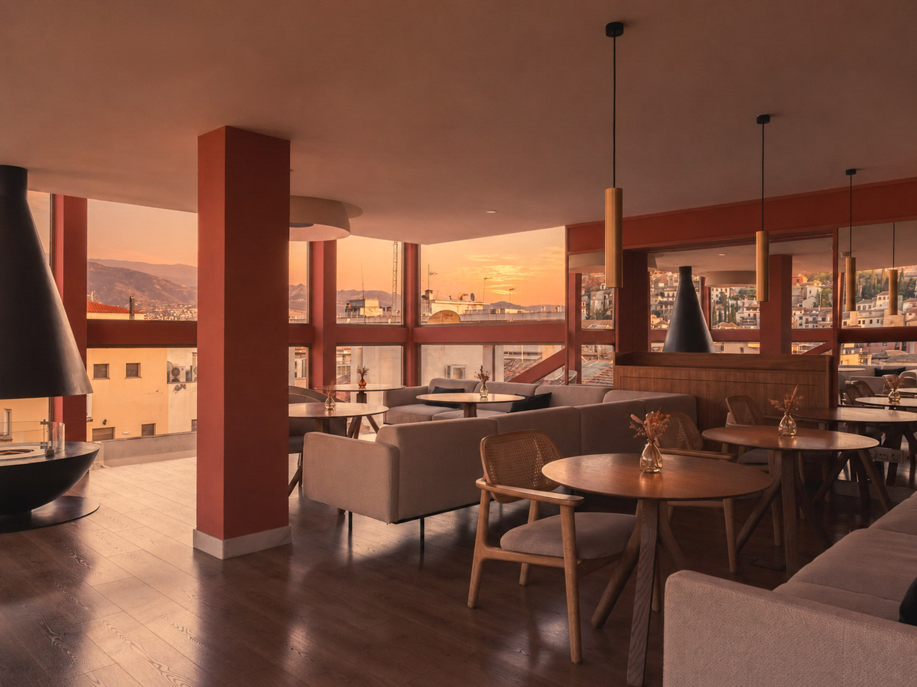 Warm modern lounge with sunset city views, stylish seating, and fireplace.