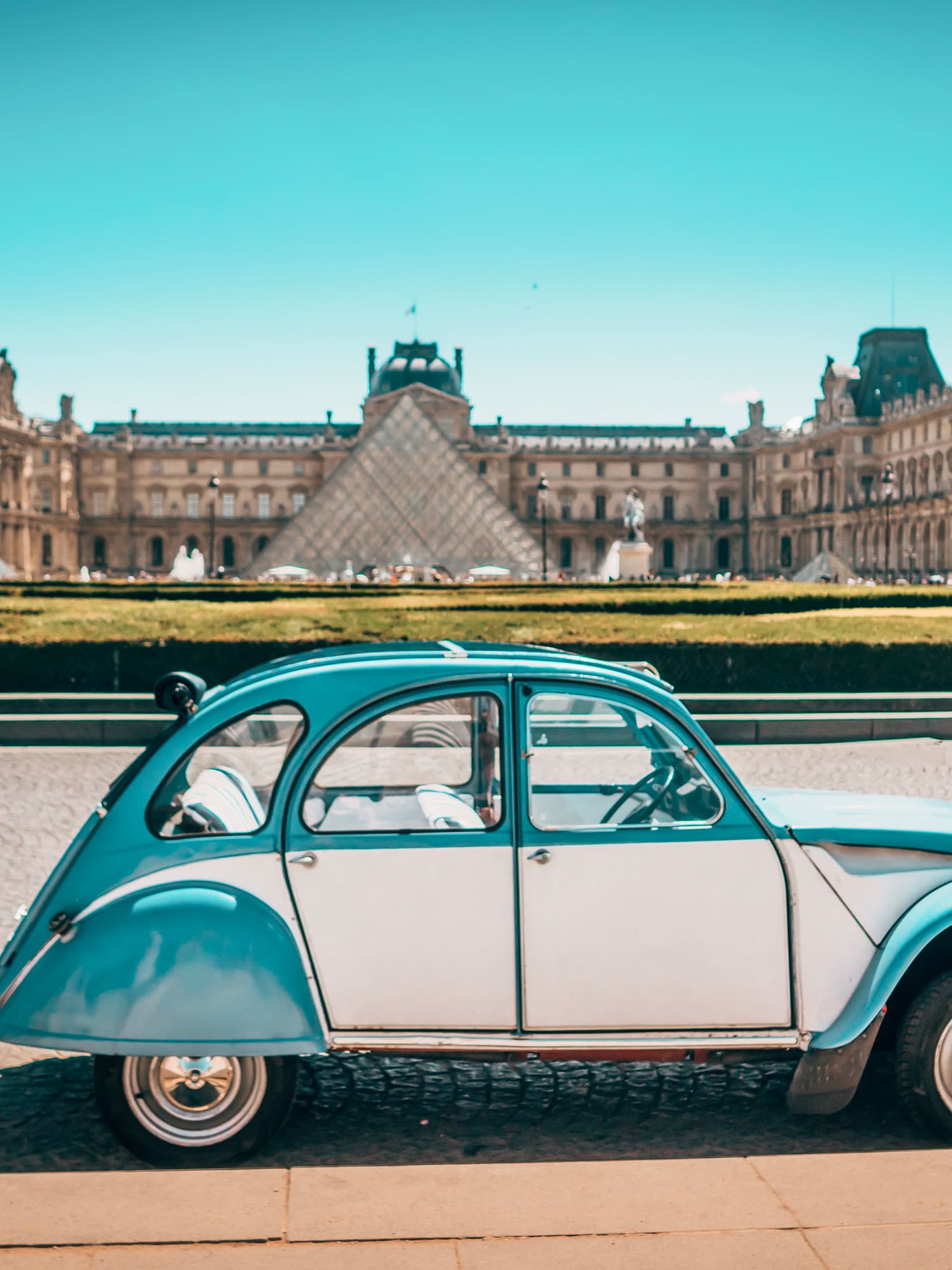 a blue and white car parked in front of a large building