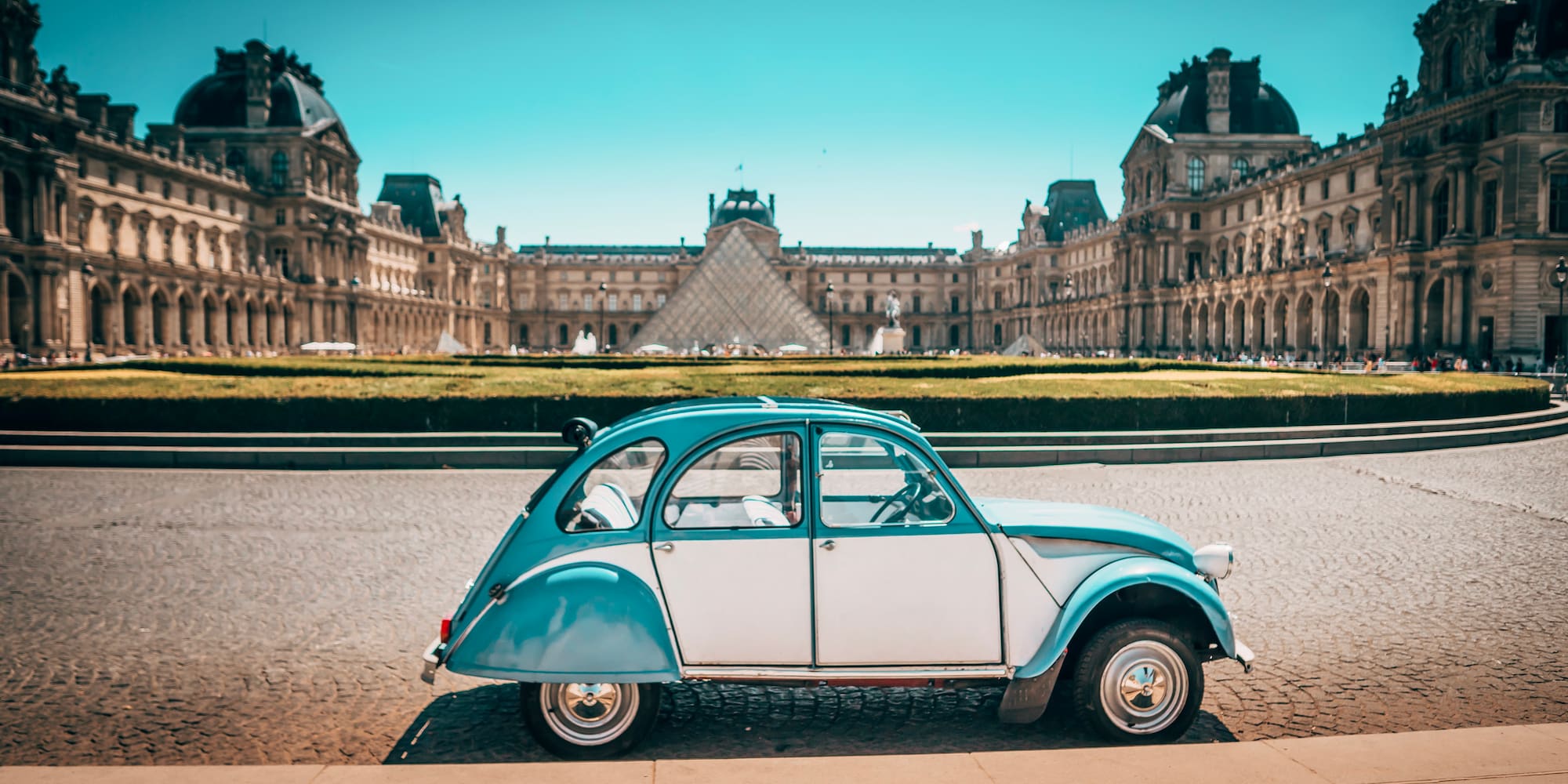 a blue and white car parked in front of a large building