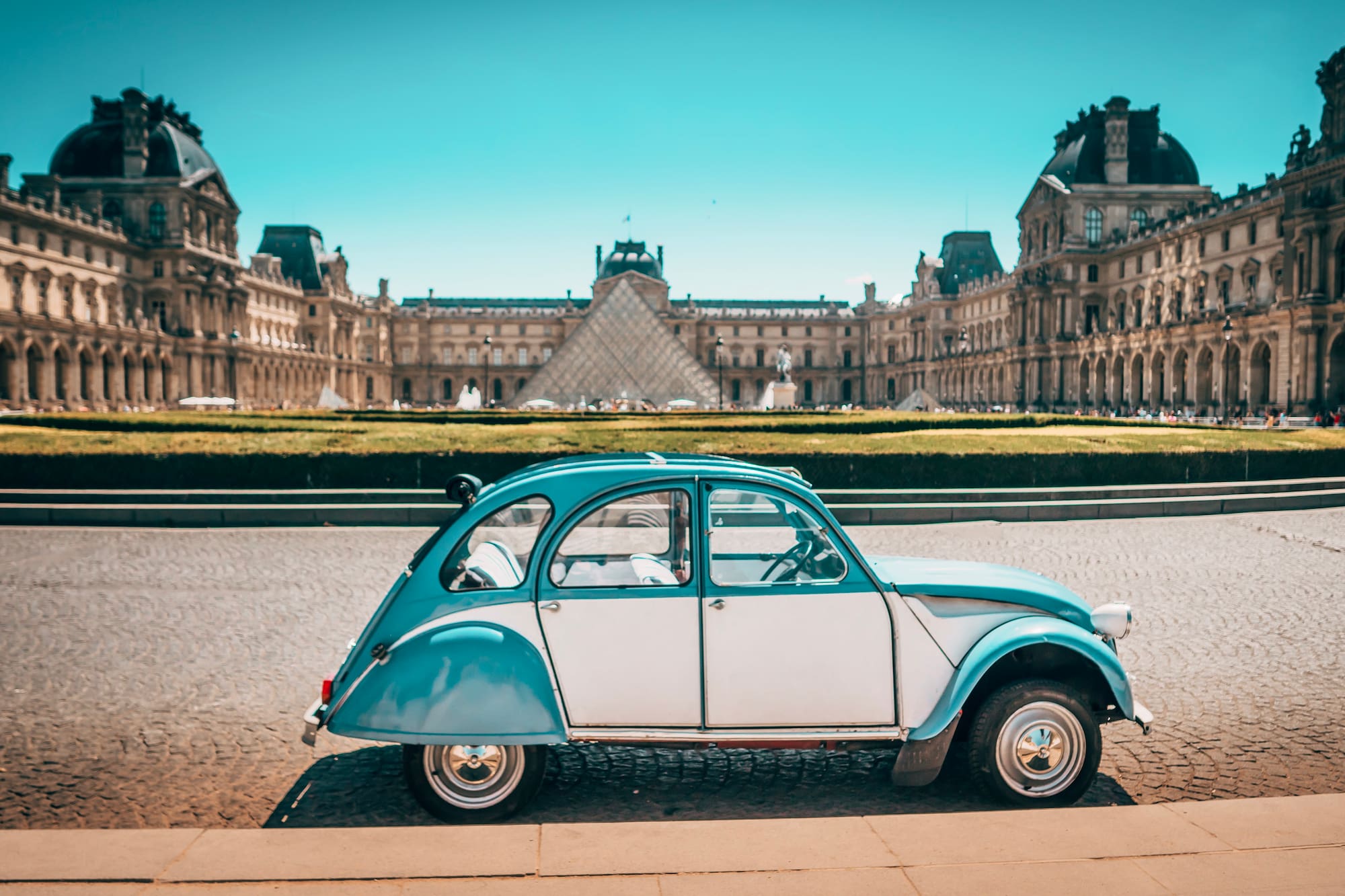 a blue and white car parked in front of a large building