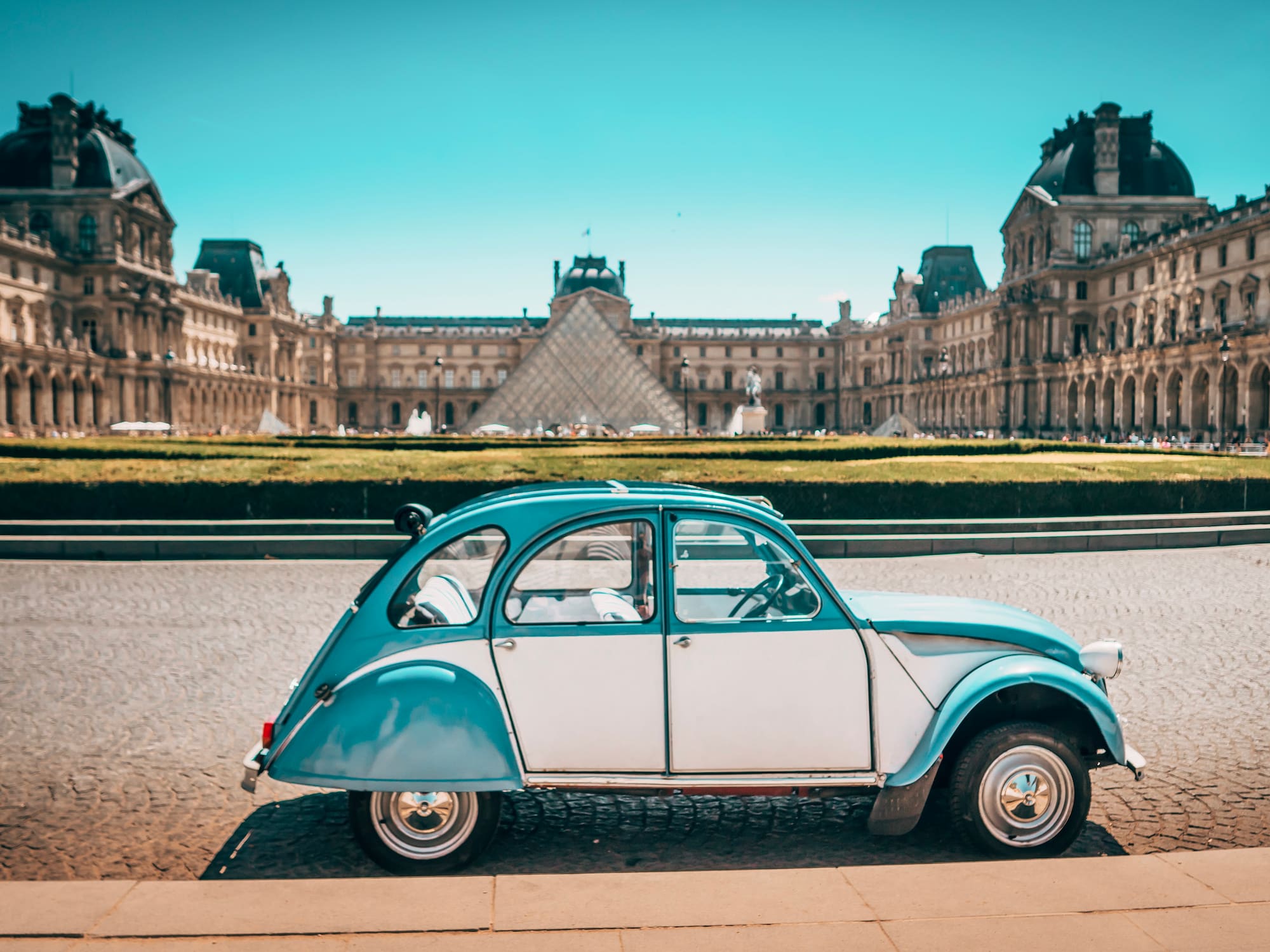 a blue and white car parked in front of a large building