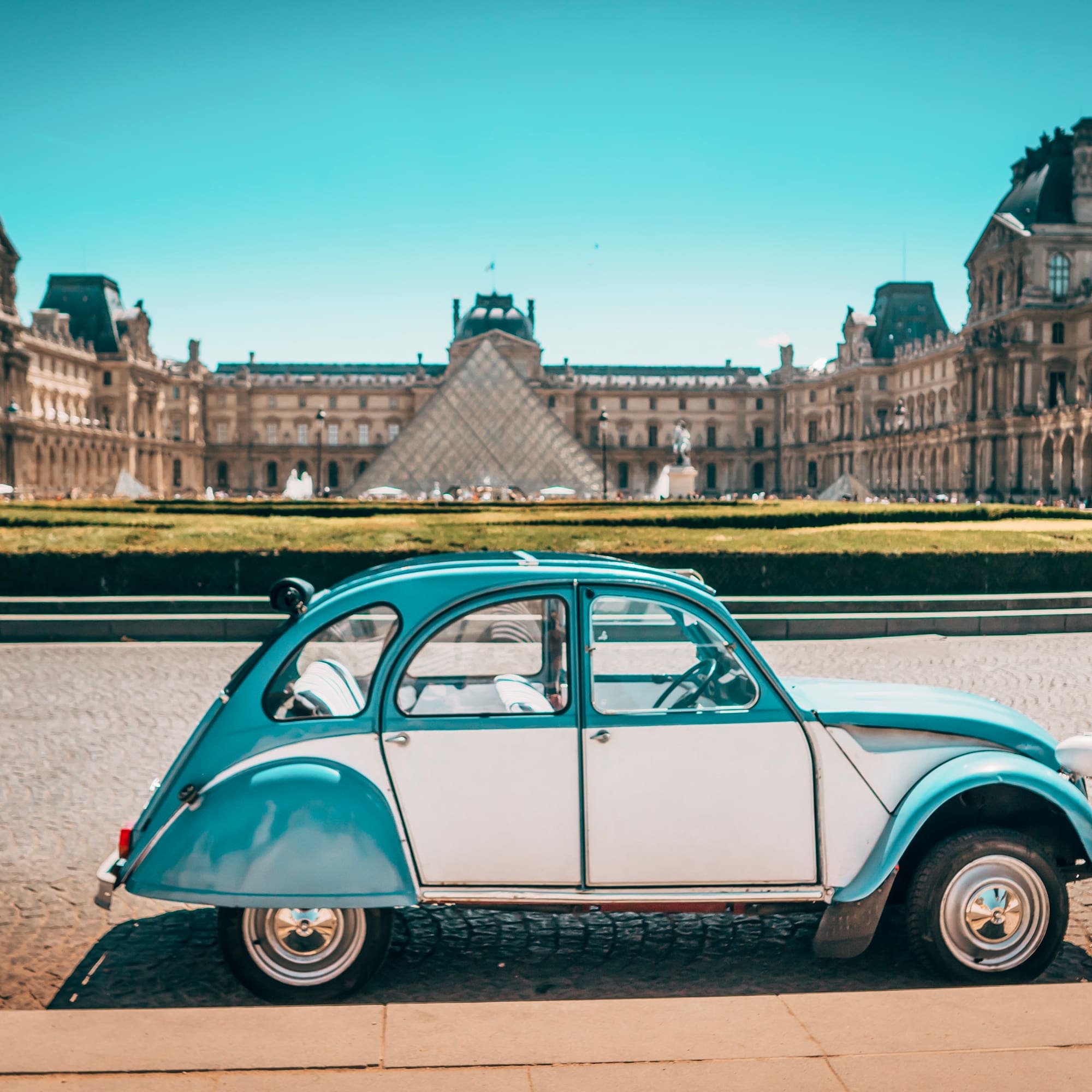 a blue and white car parked in front of a large building