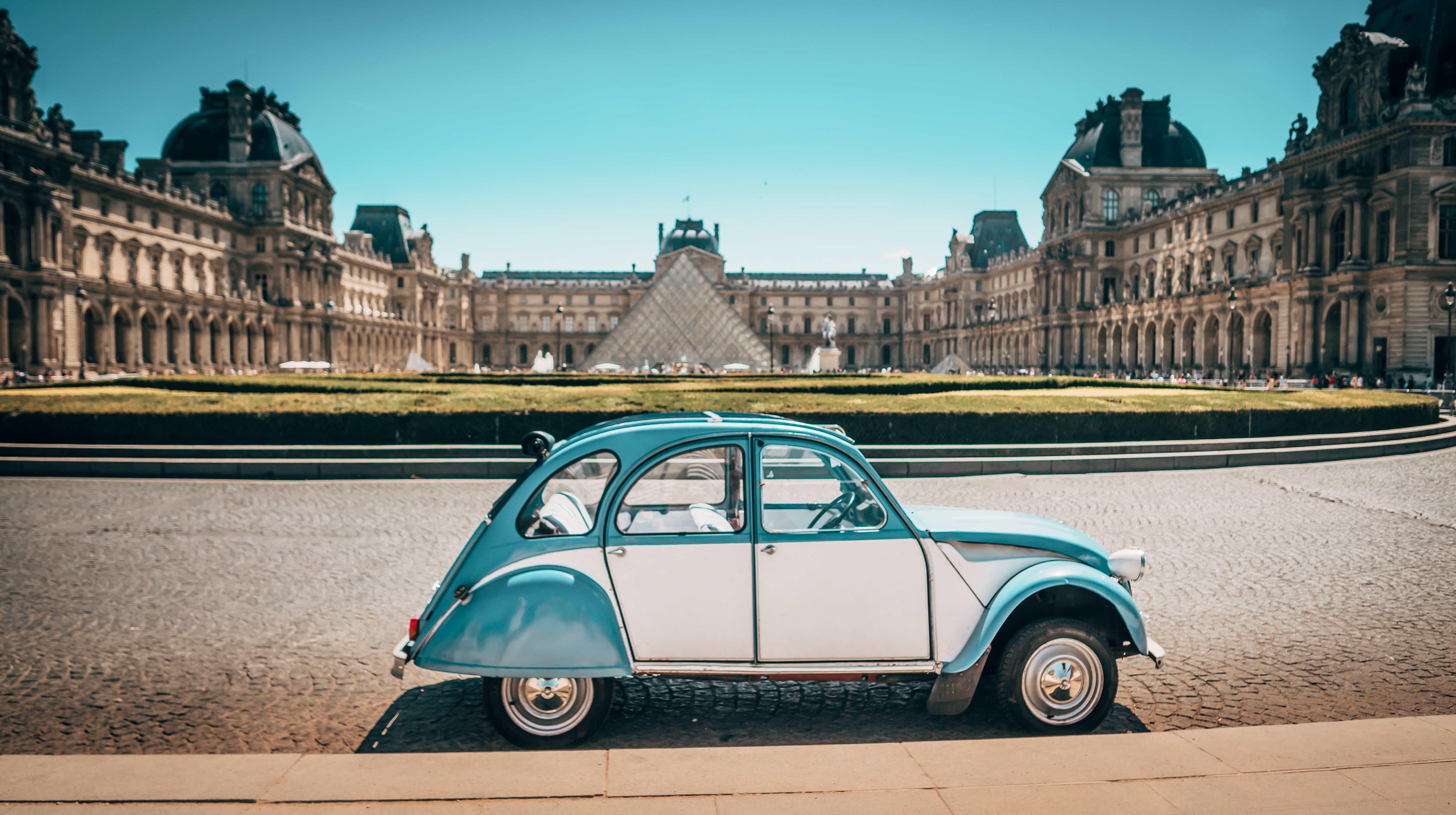 a blue and white car parked in front of a large building