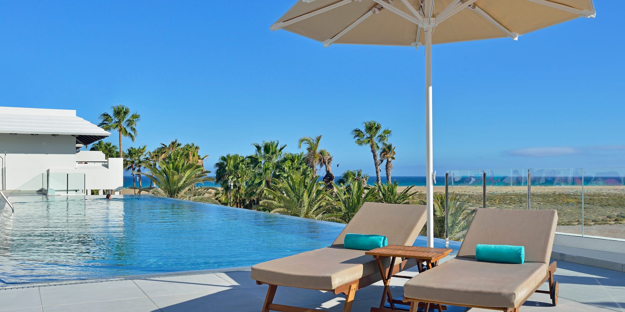 a pool with a deck chair and umbrella