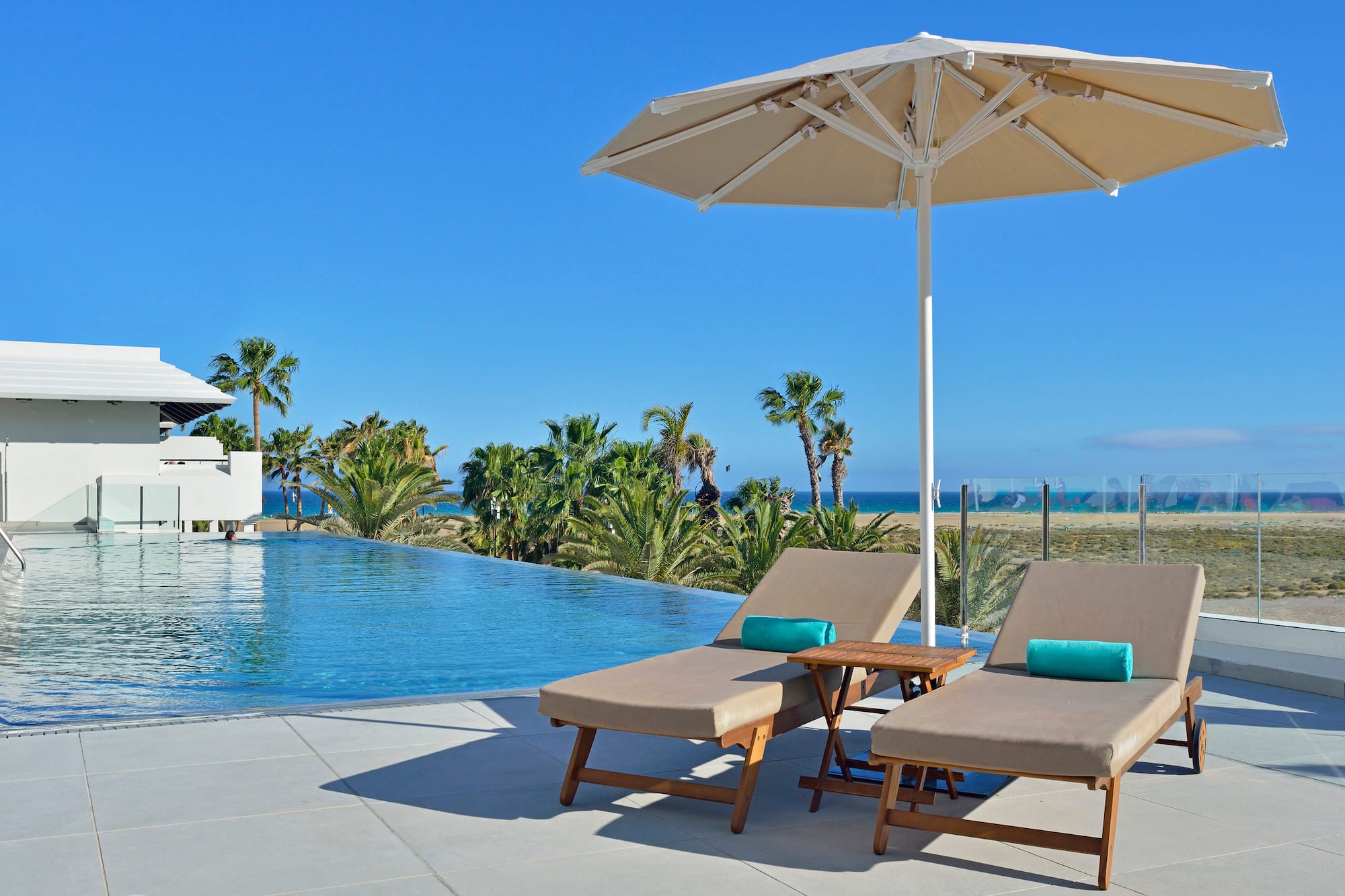 a pool with a deck chair and umbrella