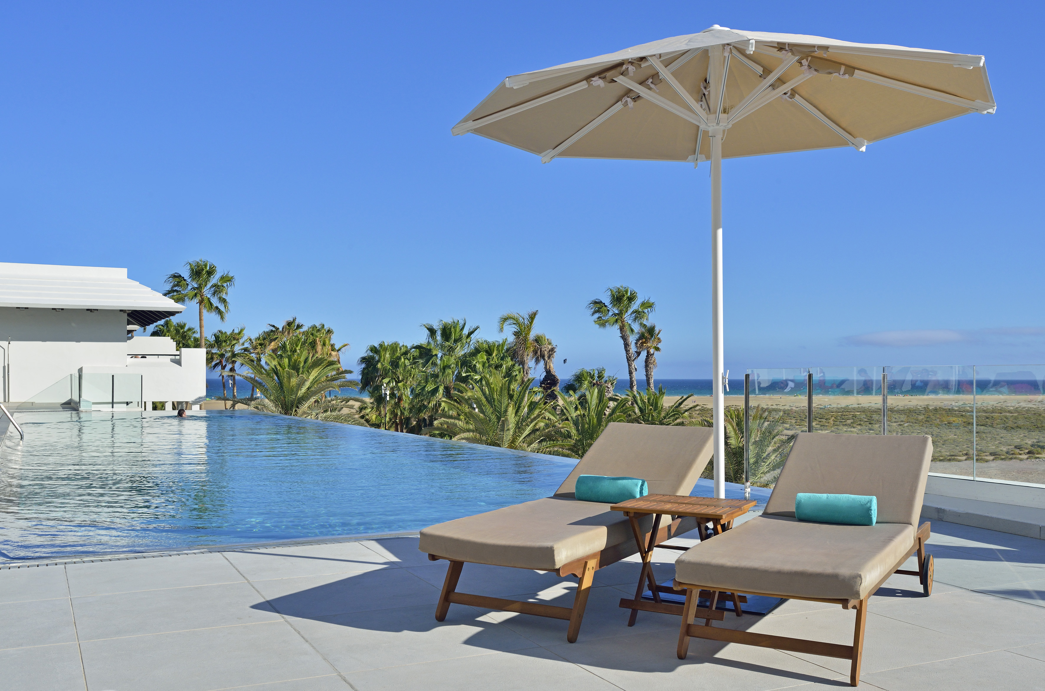 a pool with a deck chair and umbrella