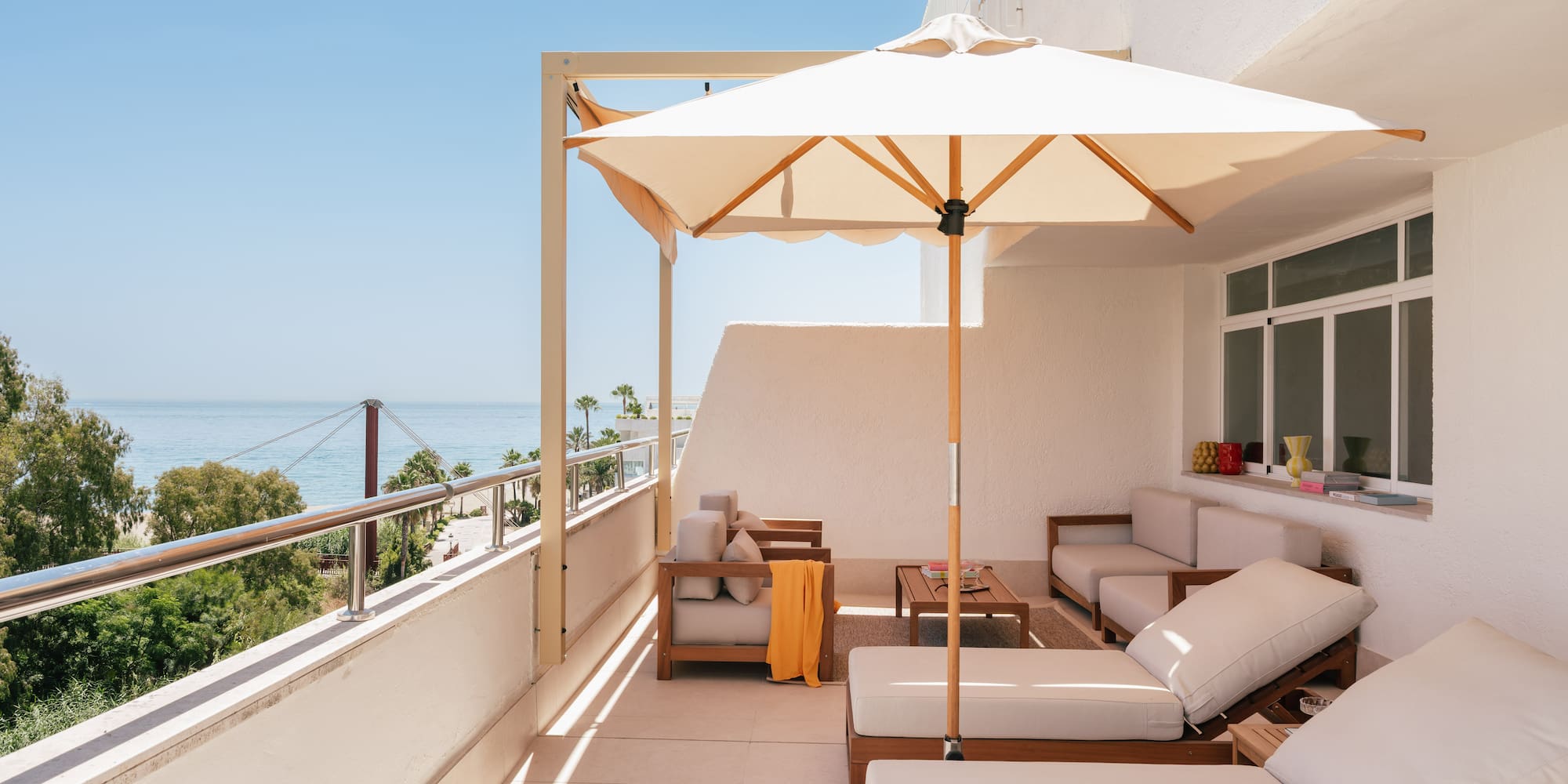 a patio with a white umbrella and chairs