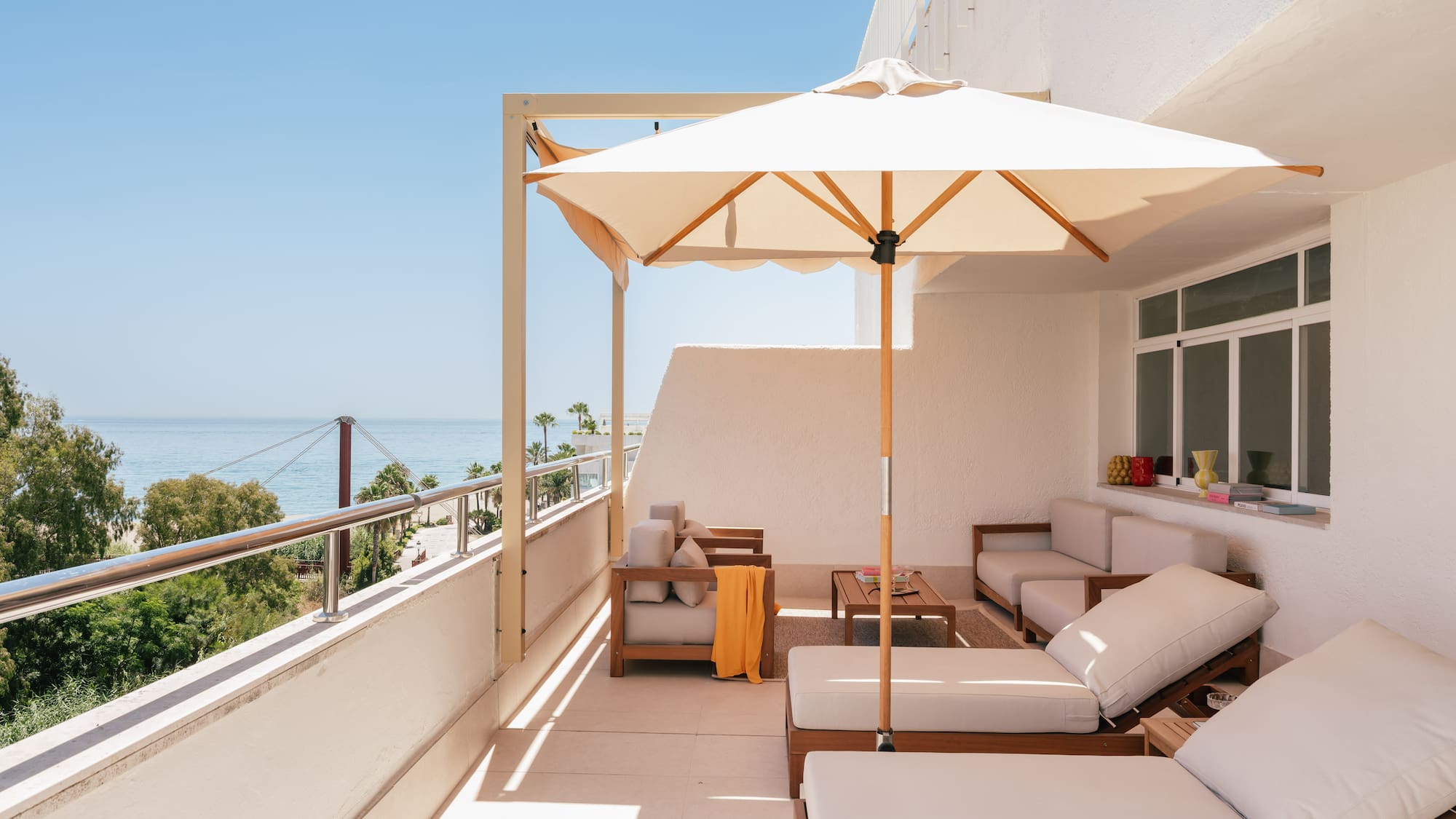 a patio with a white umbrella and chairs