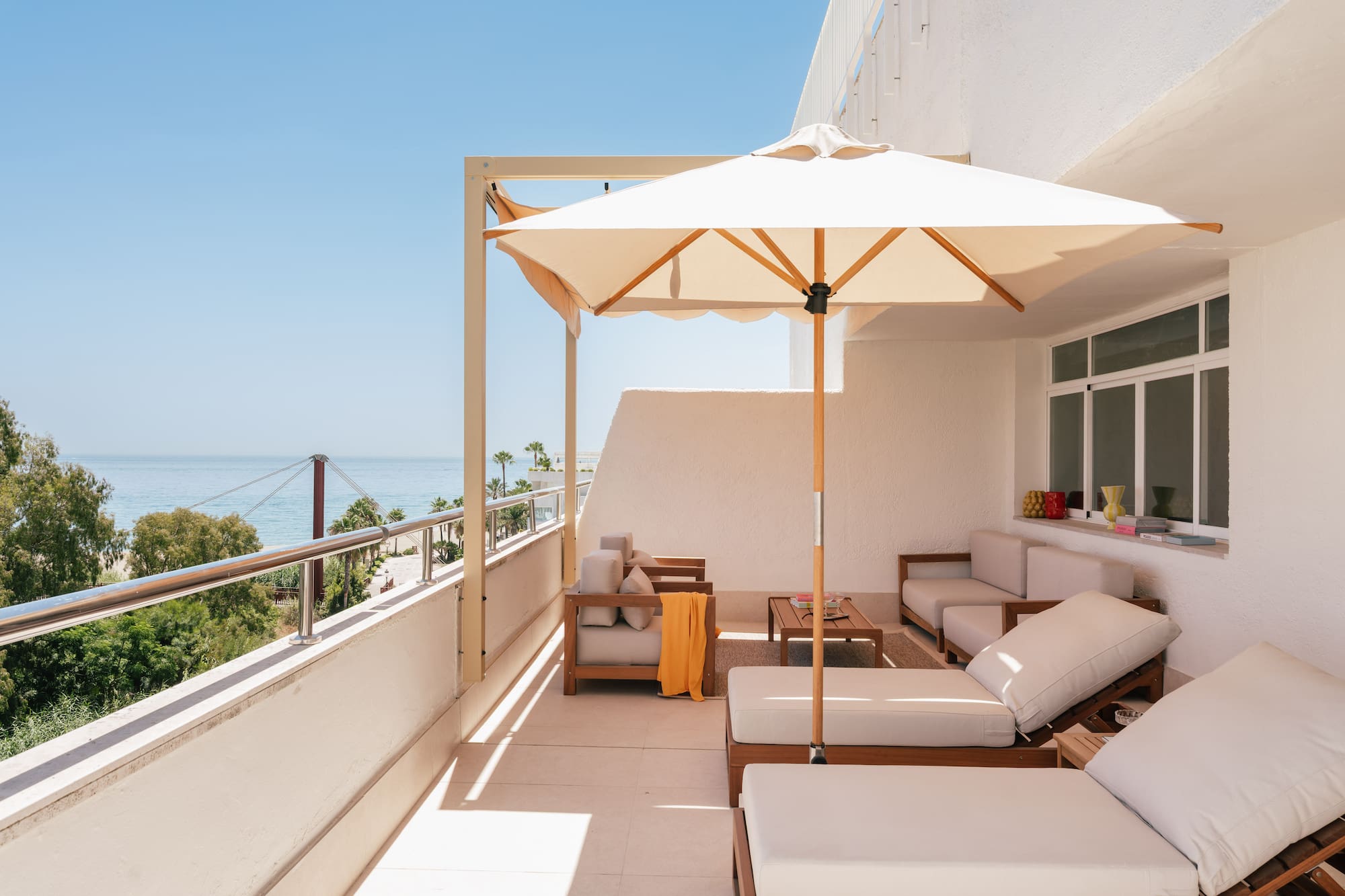 a patio with a white umbrella and chairs