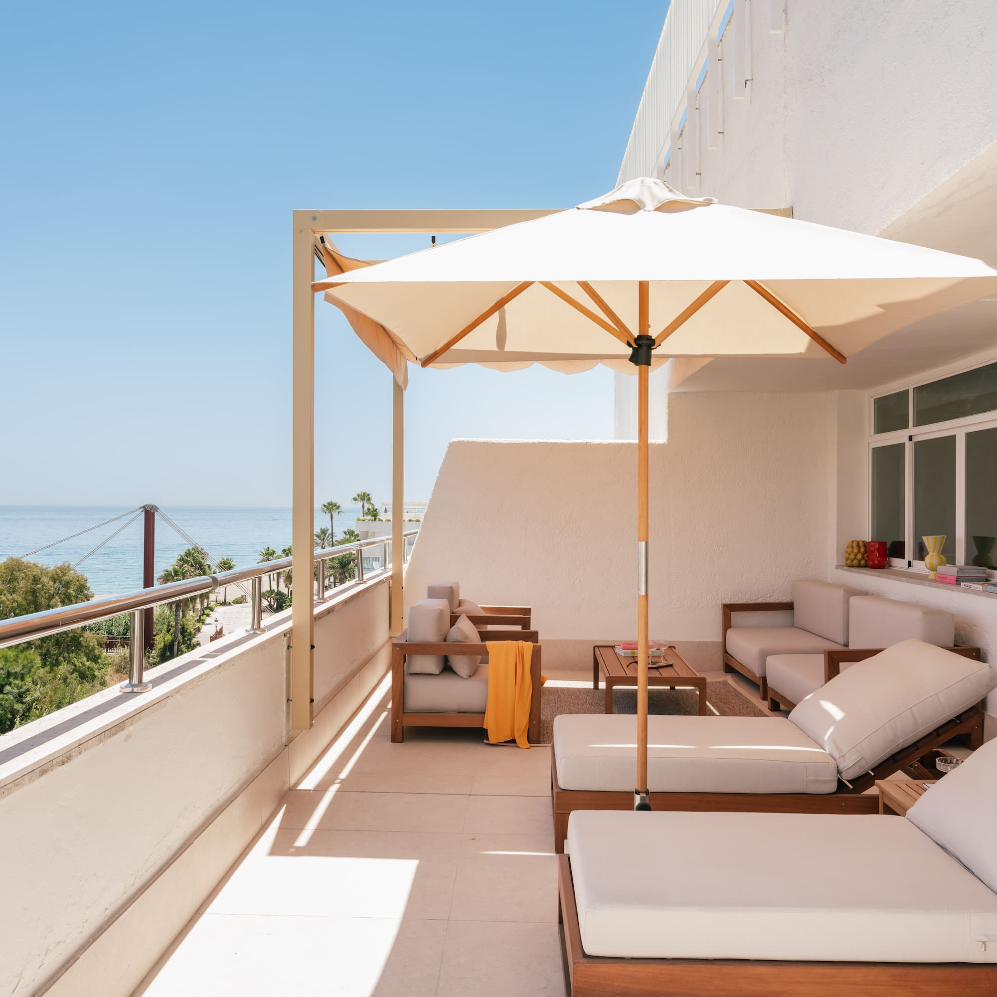a patio with a white umbrella and chairs