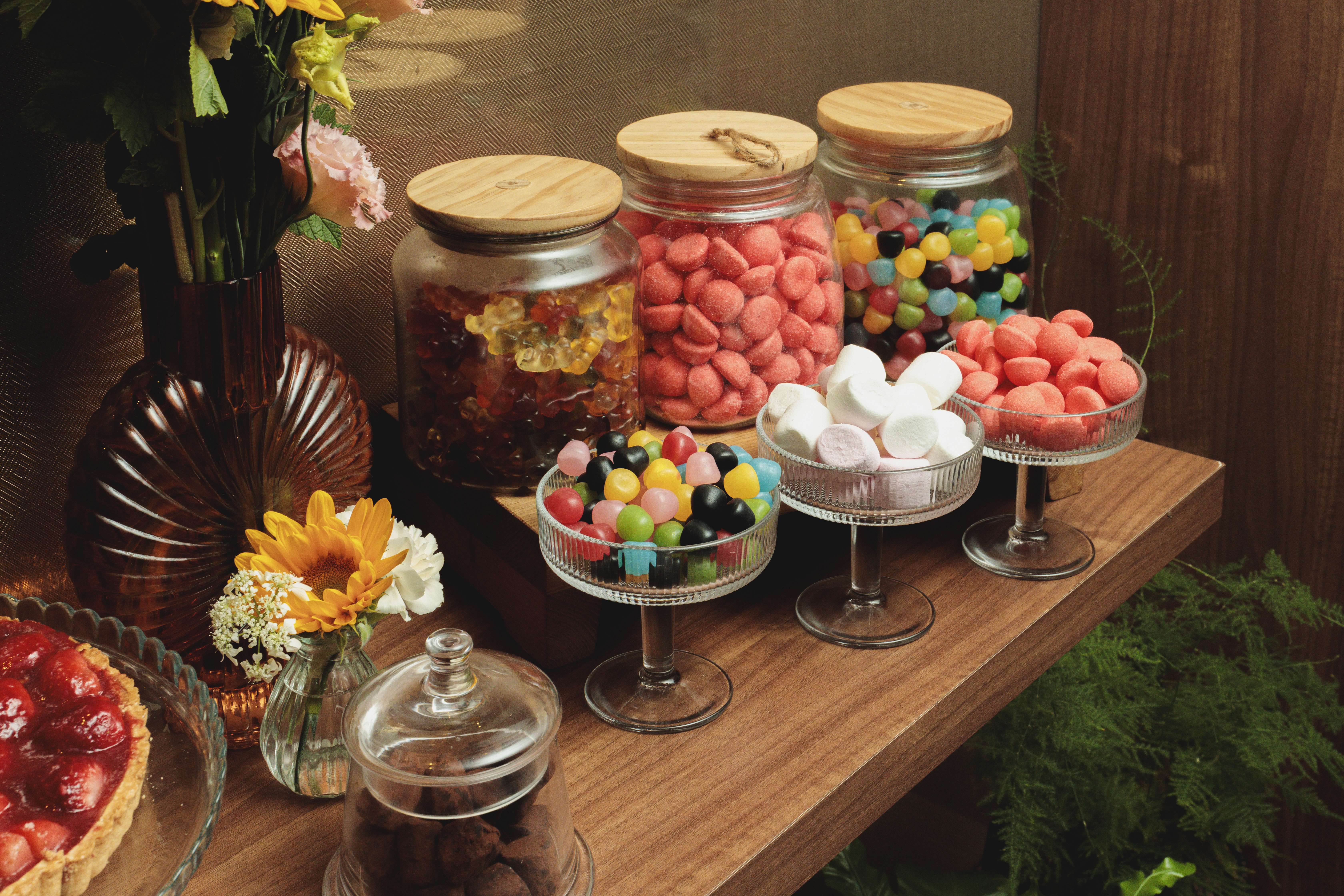 Candy bar with assorted sweets, marshmallows, gummy bears, and a strawberry tart.