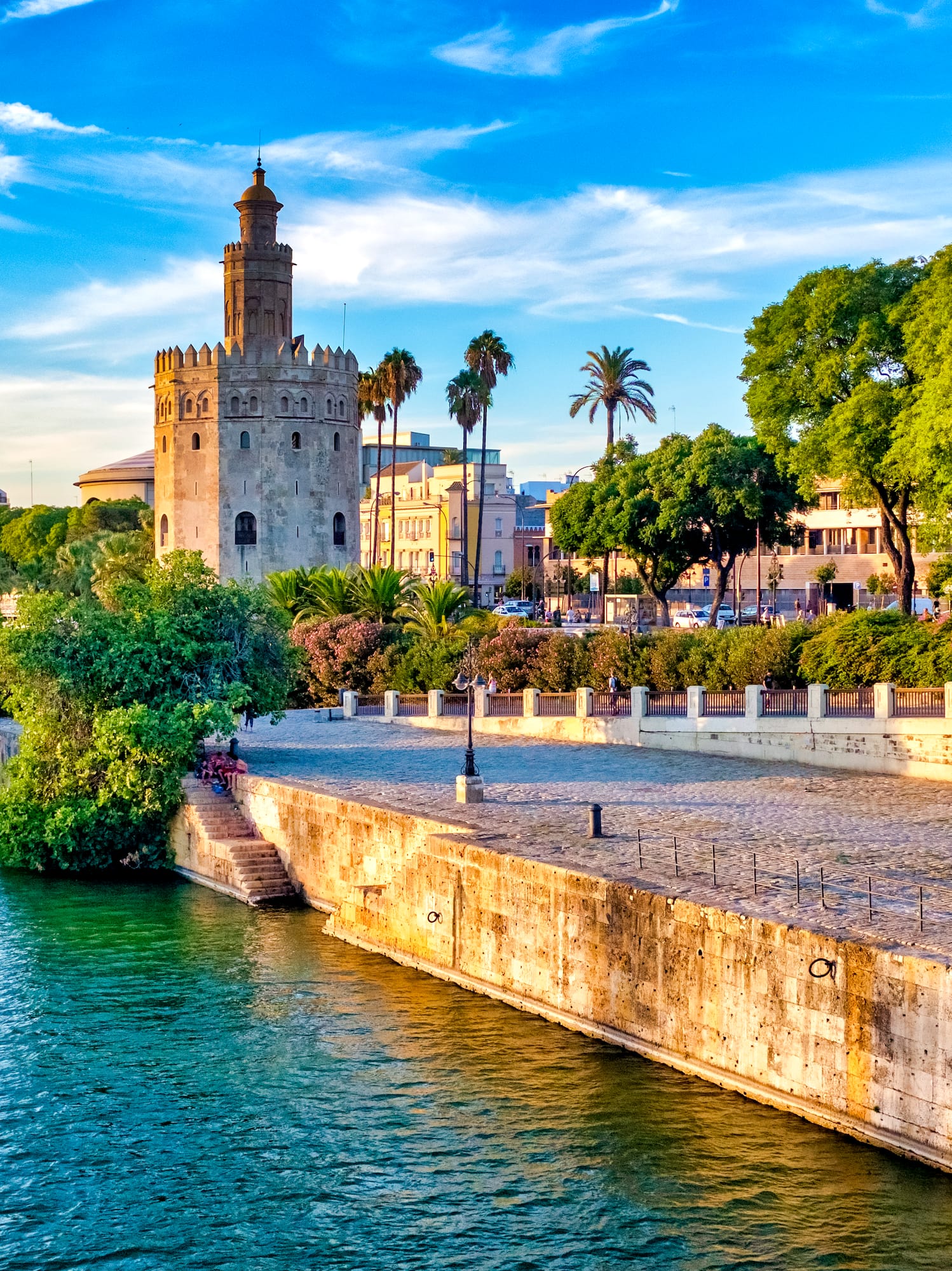 Seville's Torre del Oro on Guadalquivir River with tour boats.