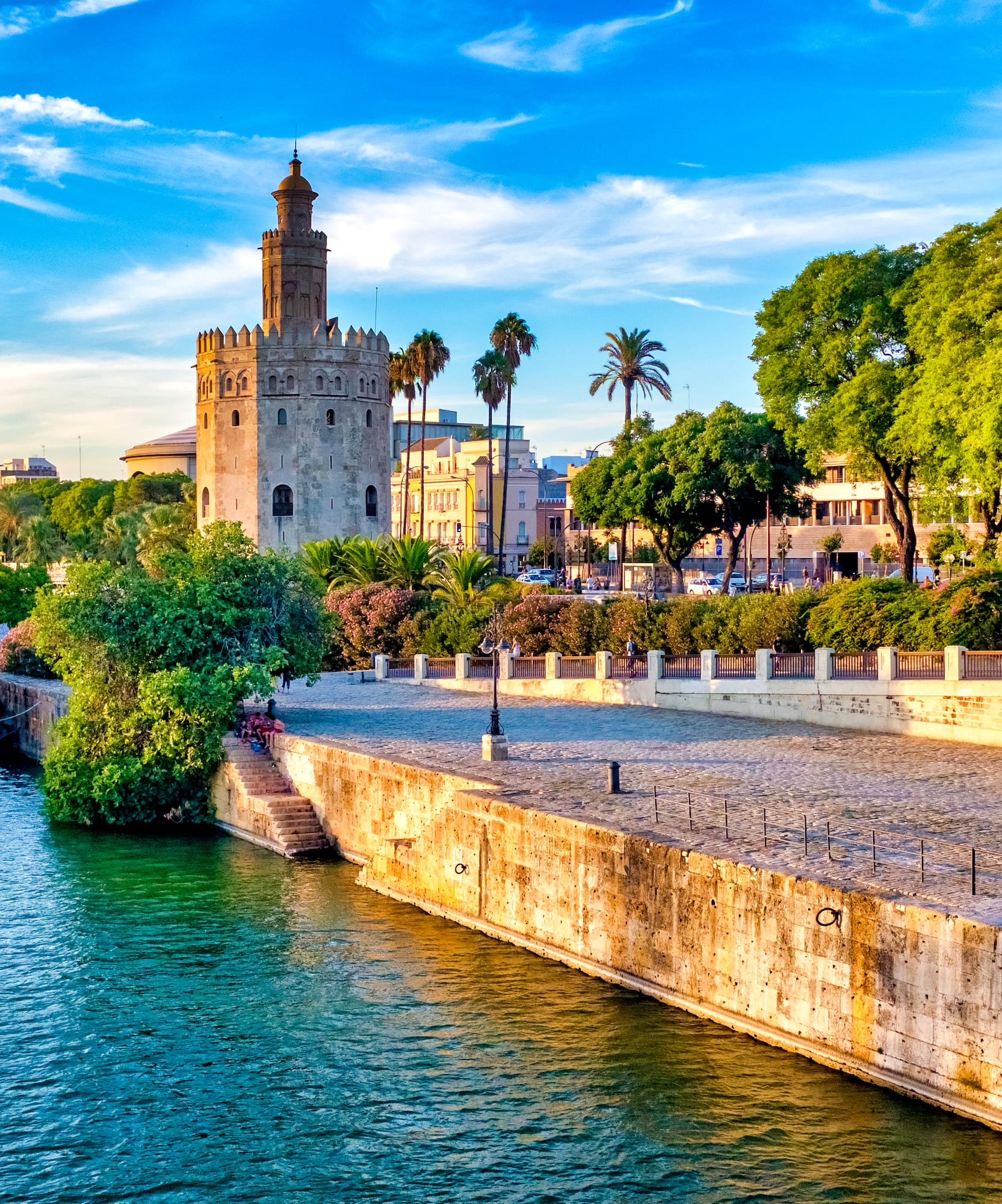 Seville's Torre del Oro on Guadalquivir River with tour boats.